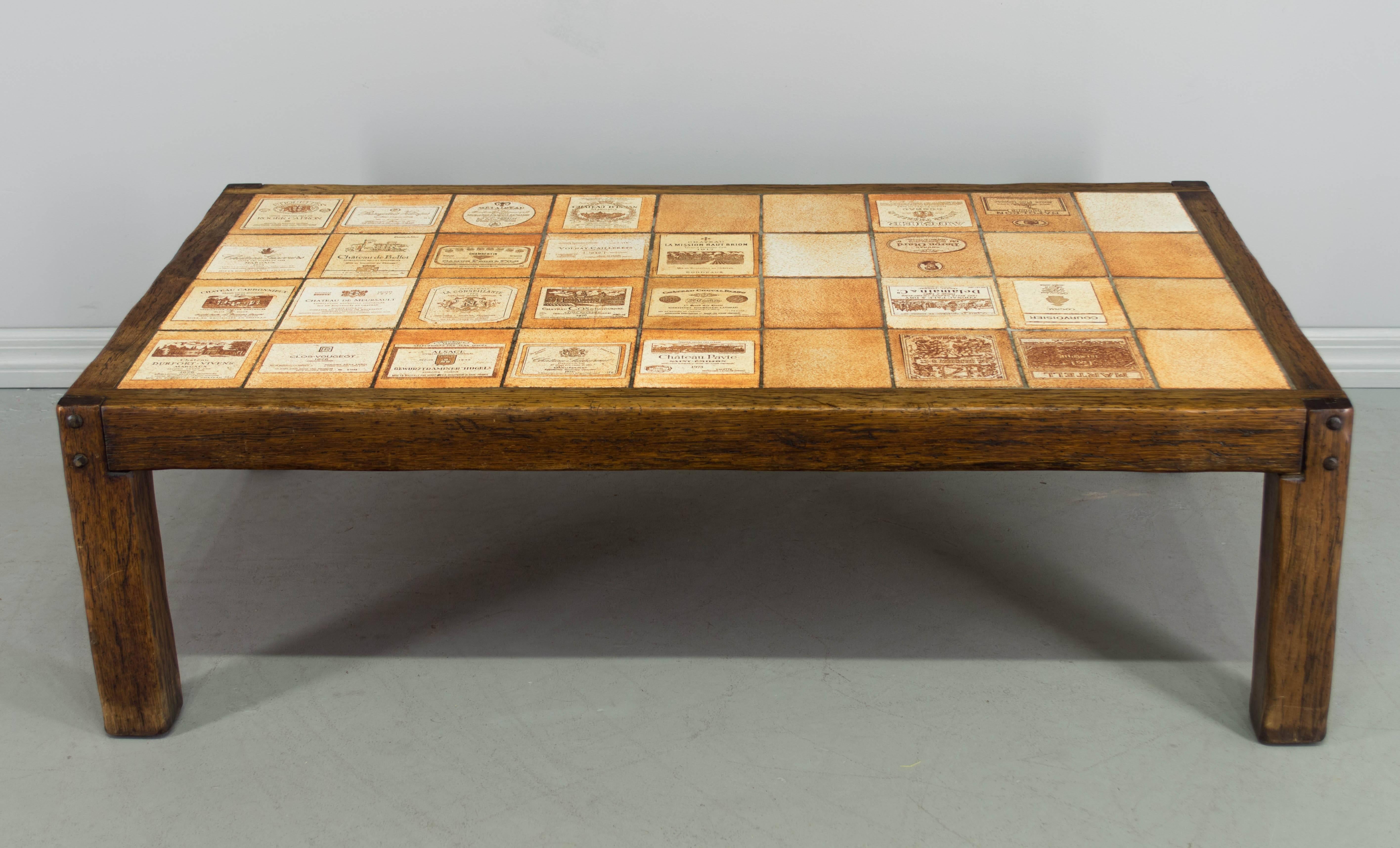 Coffee table by ceramicist Roger Capron with surface made of tiles depicting labels of notable Fine French wines. Base is made of solid oak with pegged construction. All original. Clever signature tile in upper left corner makes note of his 1954