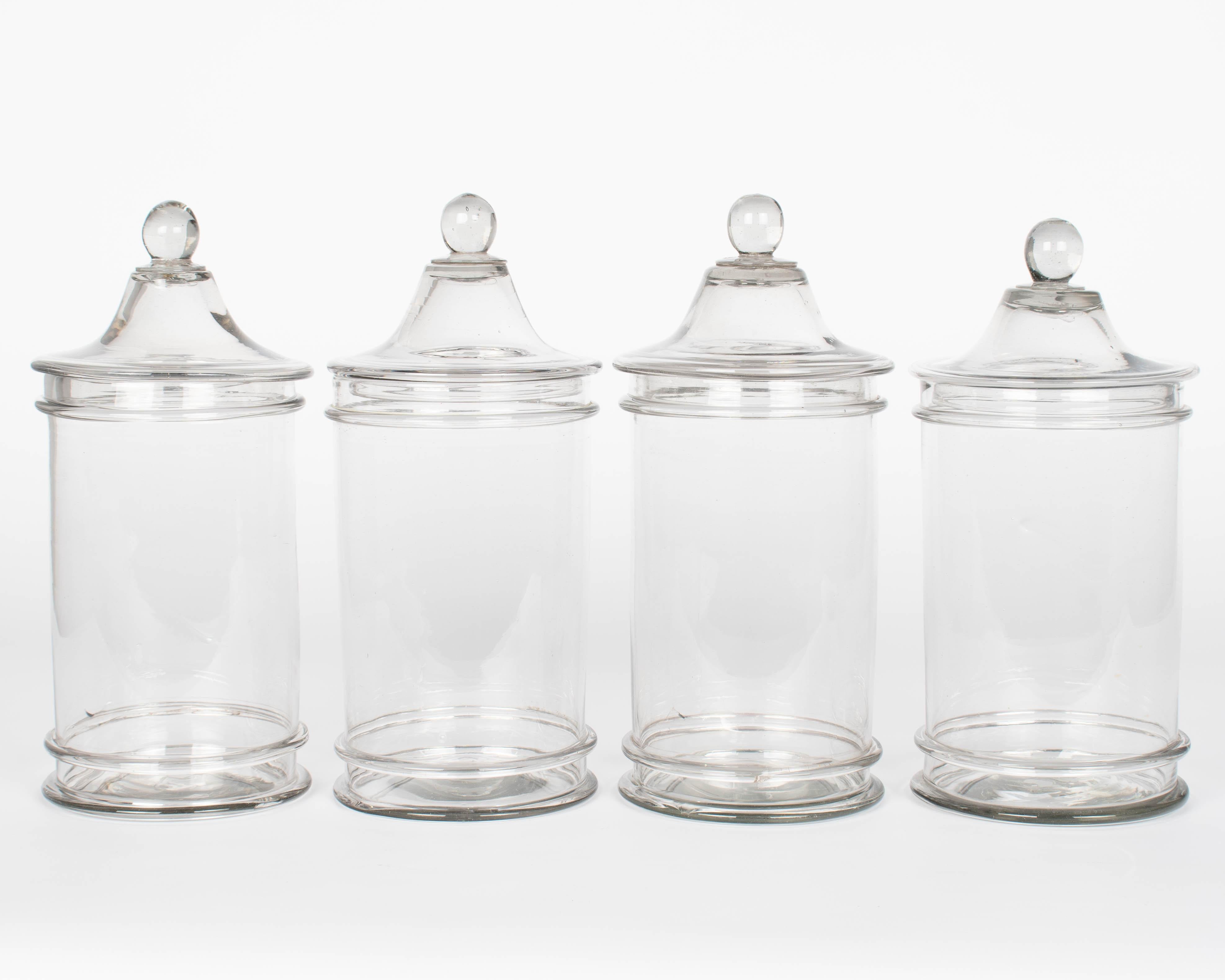 Un ensemble de quatre bocaux à couvercle en verre soufflé à la bouche, ou bocaux à bonbons. Forme de boîte lisse avec bouton sur le couvercle. Parfaites pour une utilisation dans la salle de bain ou pour des présentations décoratives de coquillages,