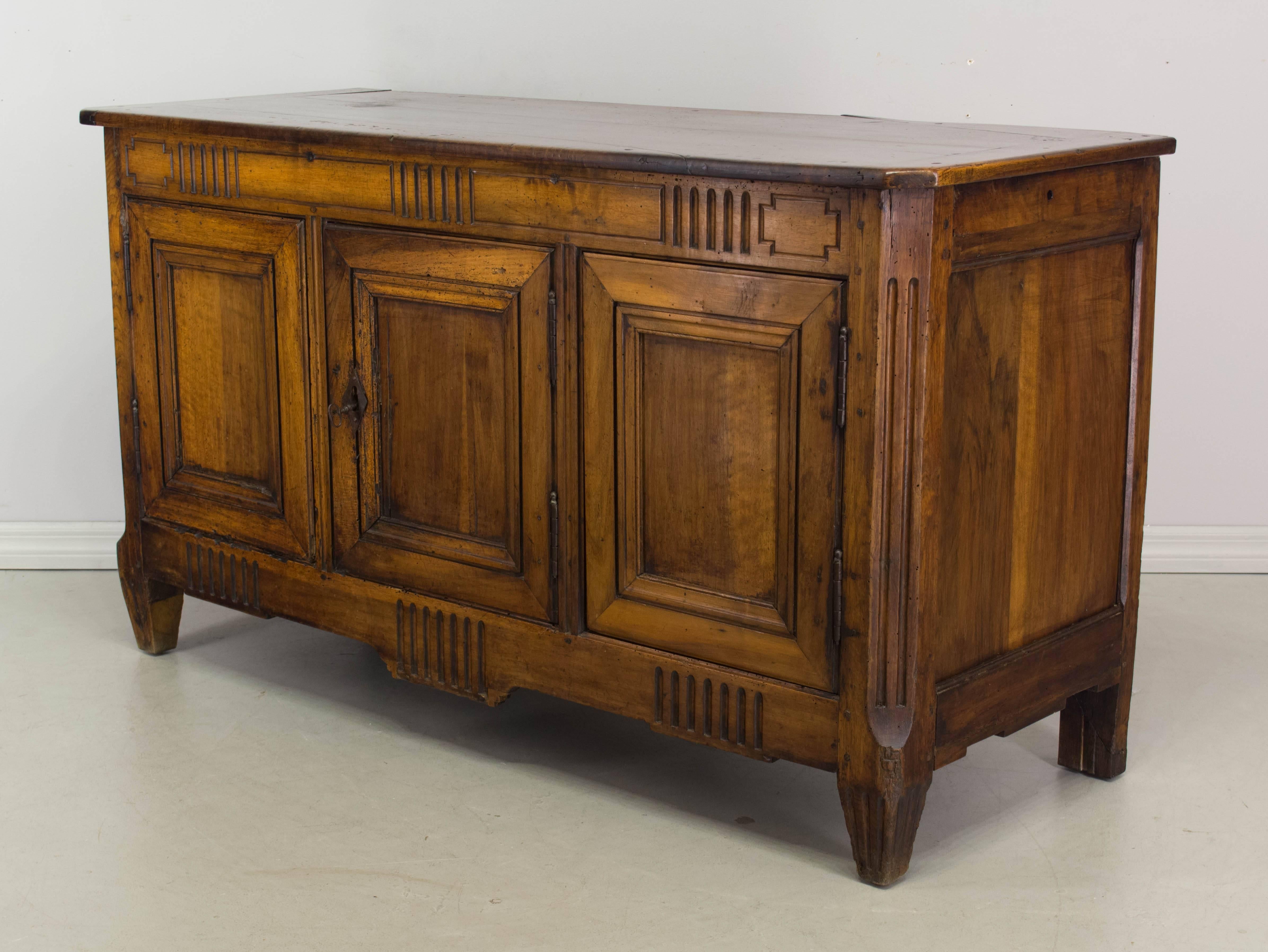 18th century Louis XVI Provençal enfilade, or sideboard, made of walnut with simple carved details. Three doors opening to one interior shelf. Lock in working order with one key. Waxed patina. Good restored condition: legs and top right corner. We