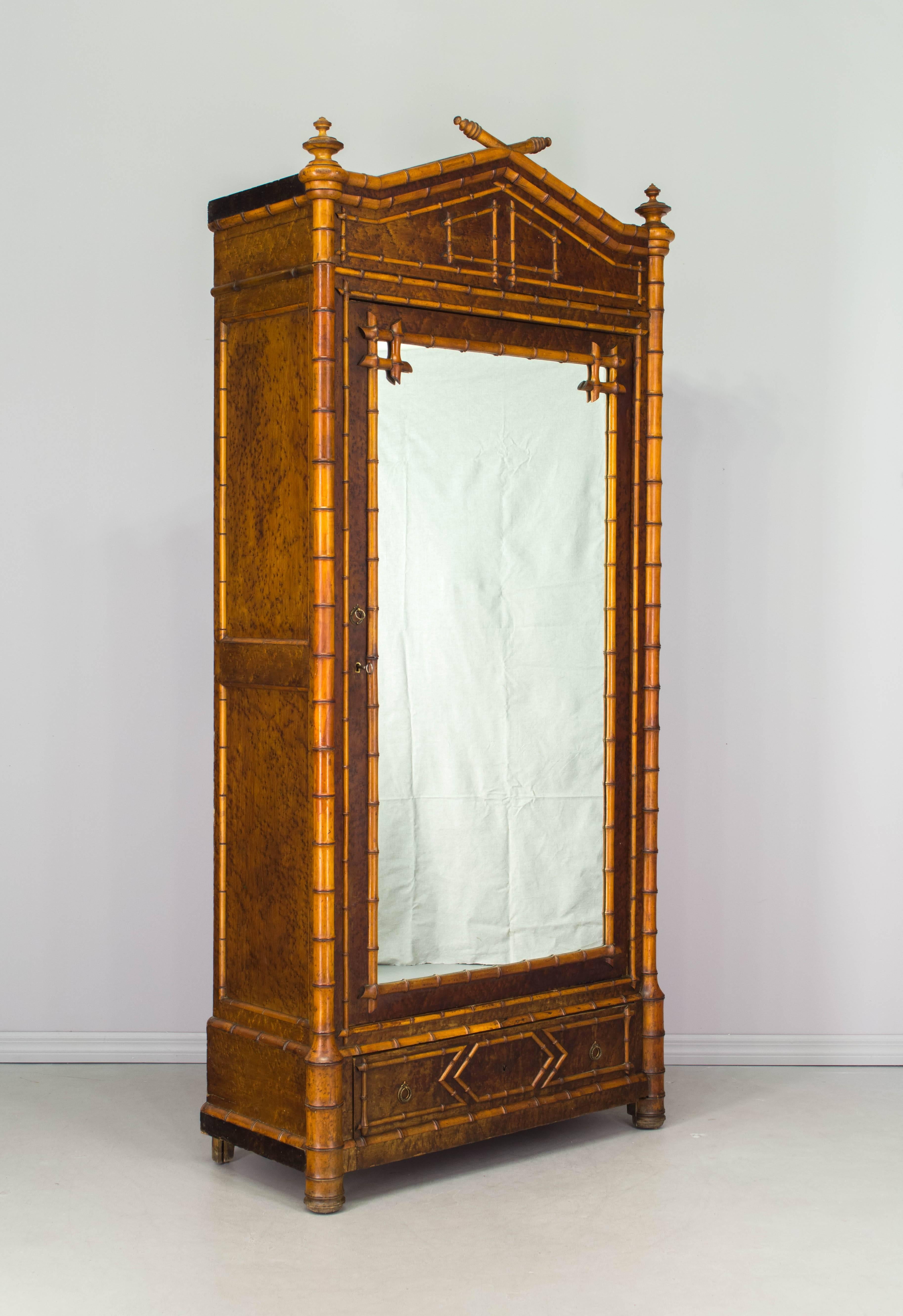 19th century French faux bamboo armoire made of solid cherry and bird's-eye maple veneer with oak as a secondary wood. Mirrored door opens to three adjustable shelves. Single dovetailed bottom drawer with ring pulls. Door has working lock and key.