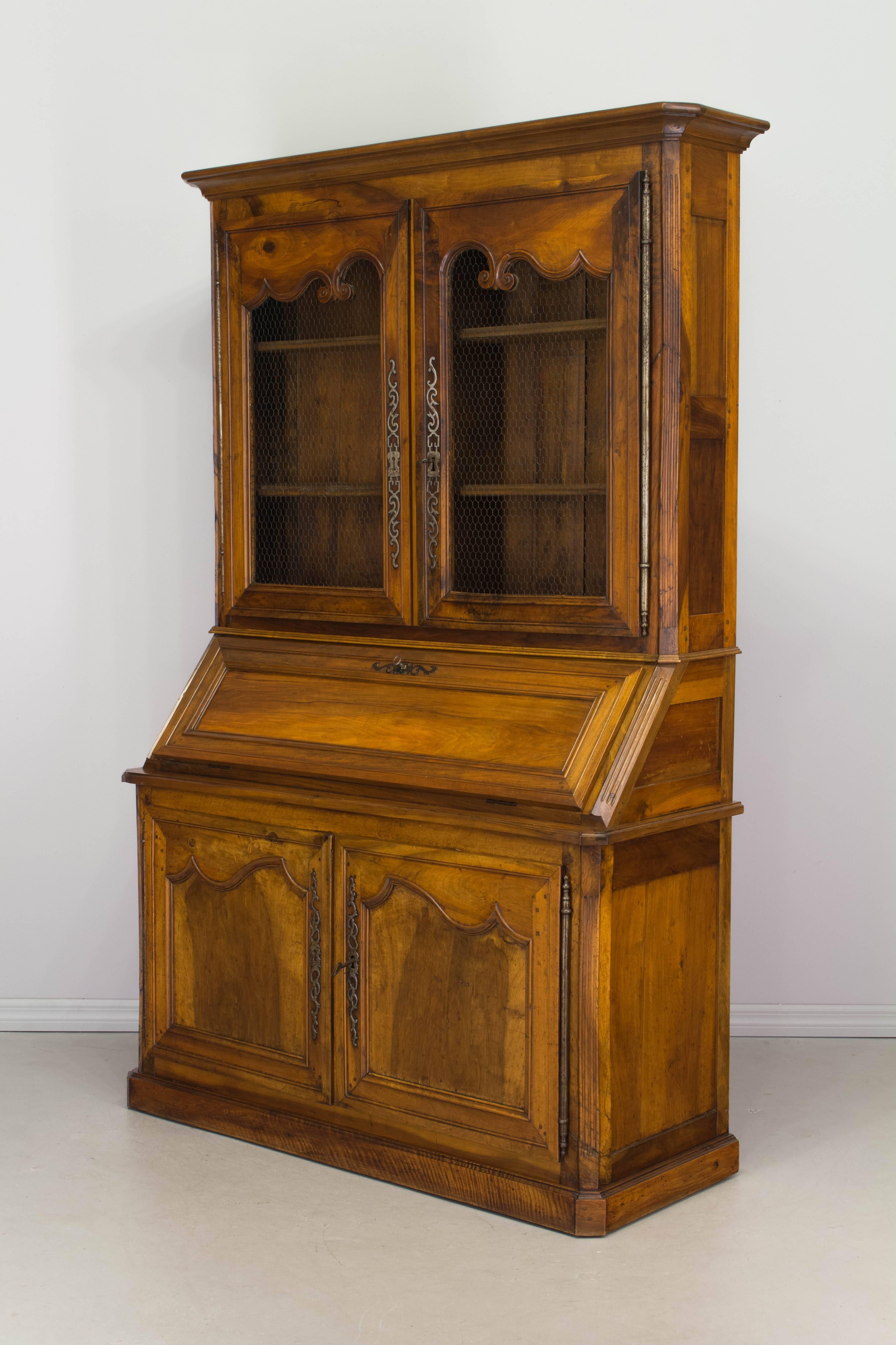 An exceptional 19th century Louis XV style scriban from the Loire Valley, made of solid walnut with pegged construction and mortise and tenon joints. The abbattant or slant front desk, hinges open to reveal a leather writing surface, a small shelf