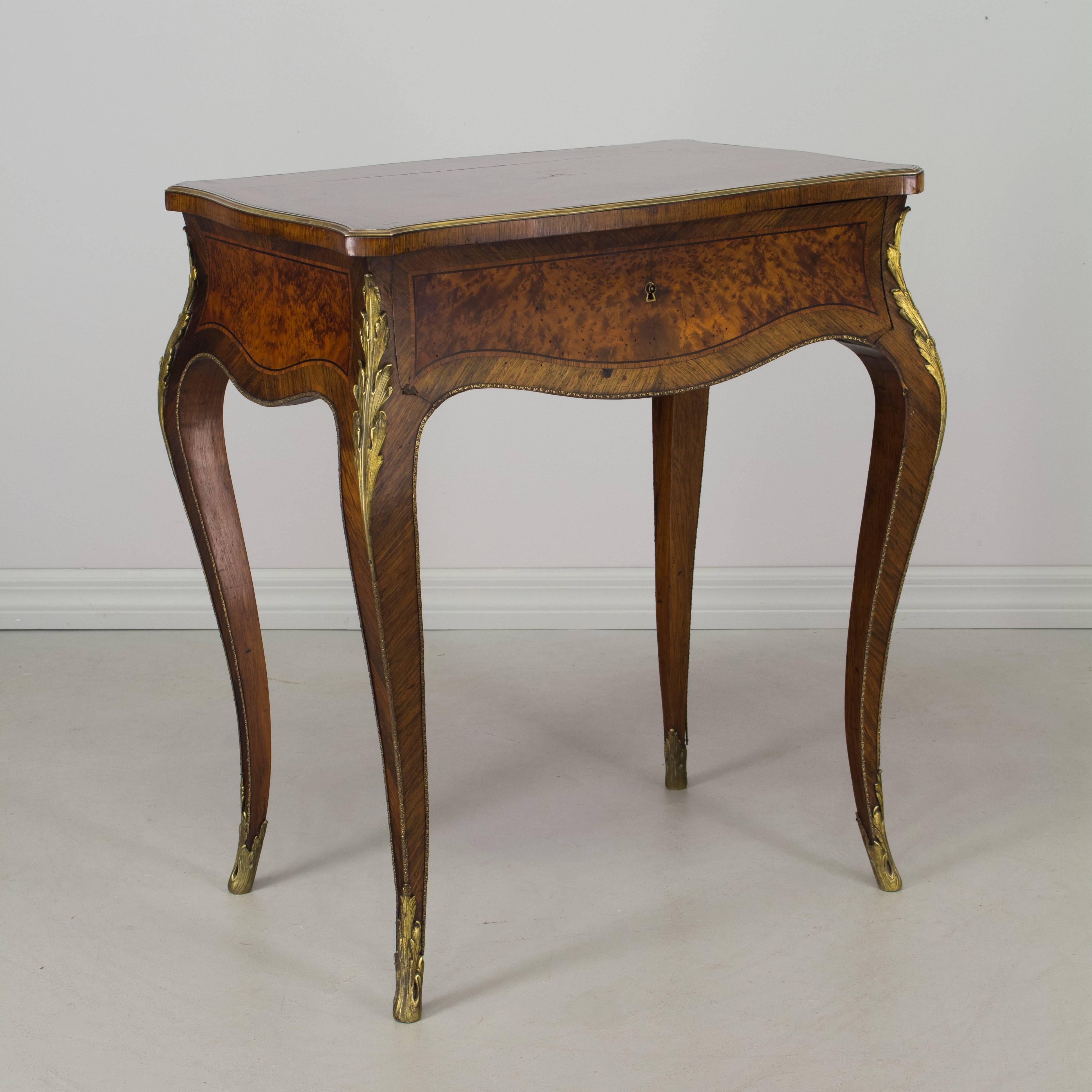 19th century Louis XV style marquetry side table with a single dovetailed drawer and hinged top with interior mirror. Made of mahogany and various wood veneers with bronze decoration. French polish finish. Exceptional craftsmanship. Etched bronze