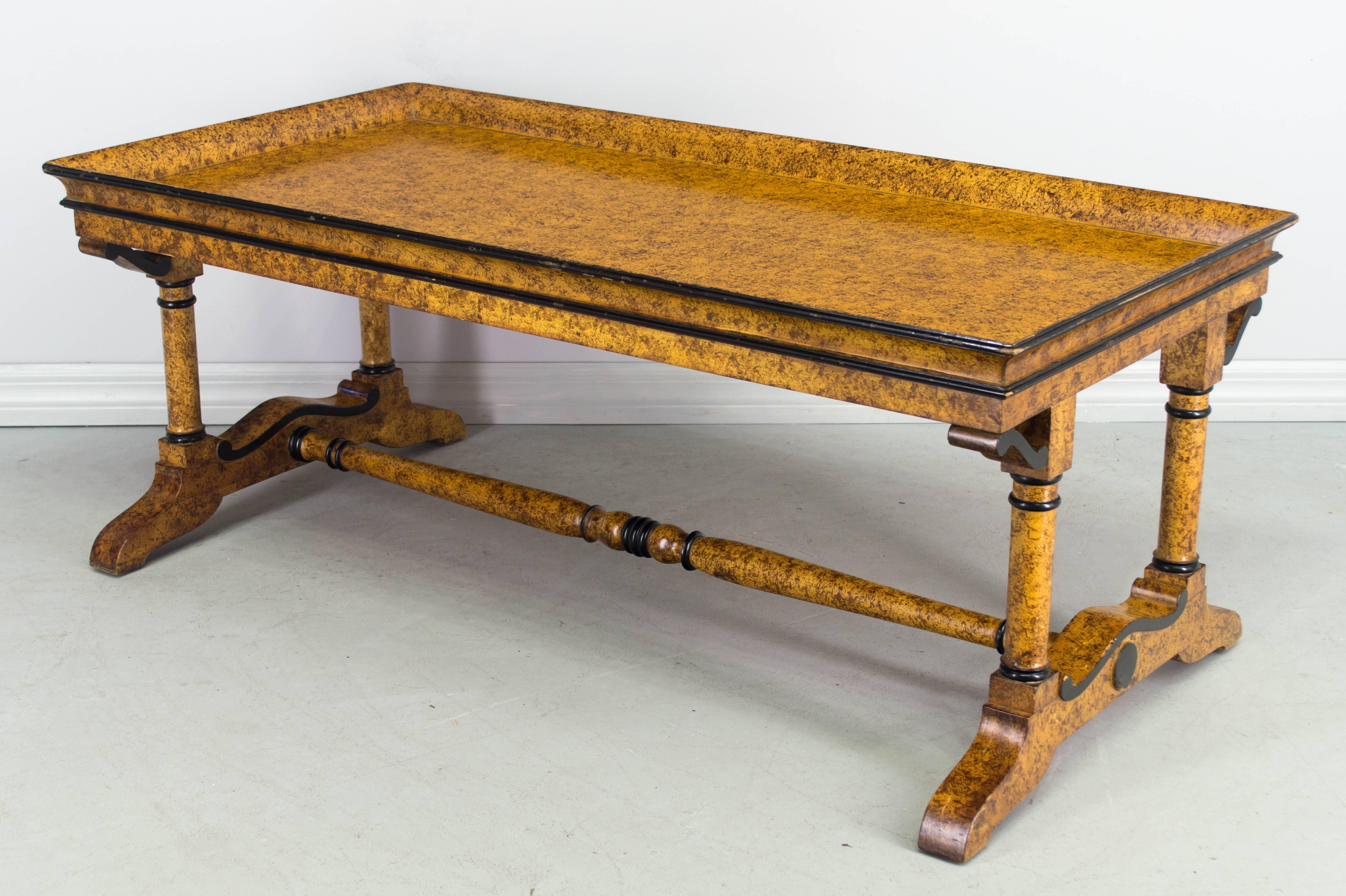 French Charles X style coffee table faux-painted to look like bird's-eye maple. Ebonized trim. More photos available upon request. 
We have a large selection of French antiques. Please visit our showroom in Winter Park, Florida.