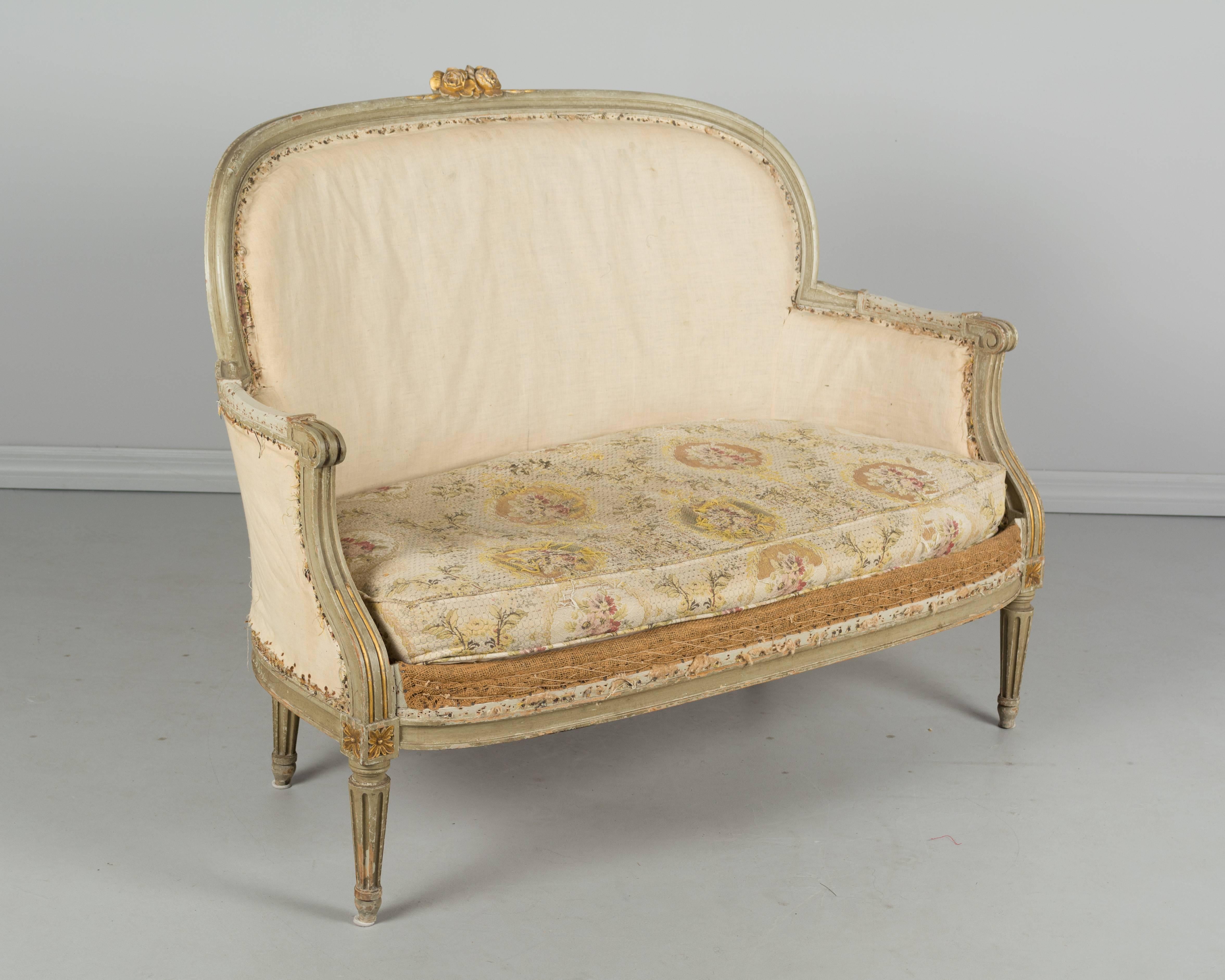 A 19th century Louis XVI style canapé or small sofa. Original verdigris painted finish with carved details and gilt accents. Sturdy with nice proportions. The right arm has been restored. The original upholstery has been partially stripped. Sold as