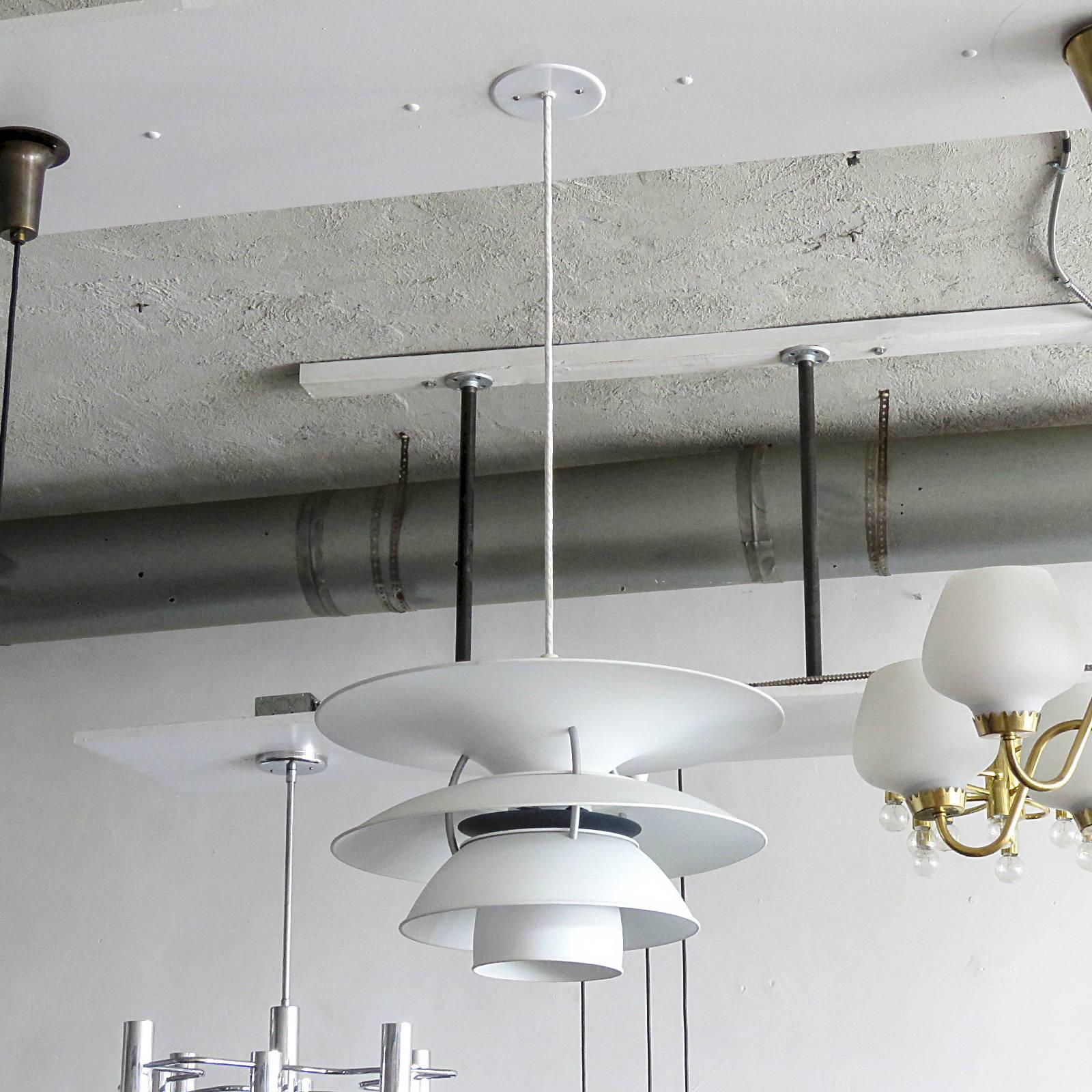Wonderful large pendants by Poul Henningsen for the Charlottenborg Exhibition Hall in Copenhagen, produced by Louis Poulsen, the enameled metal body is predominately white with grey hardware and dark blue reflector disc, current drop of 36