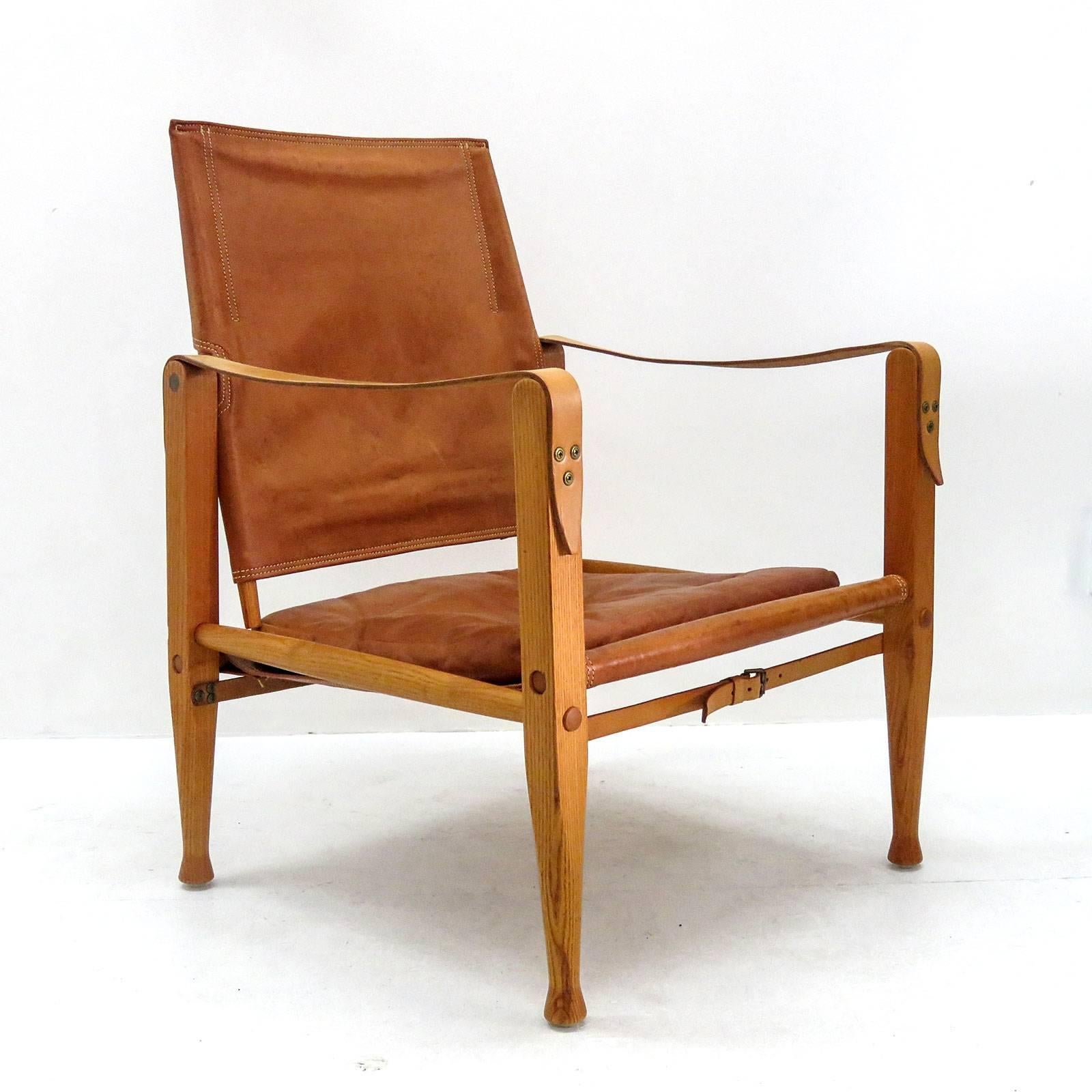 Stunning safari chair designed by Kaare Klint for Rud. Rasmussen’s Snedkerier, with patinated ash frame, seat, back, straps and loose cushion in patinated leather, designed in 1933, produced 1969, natural patina.