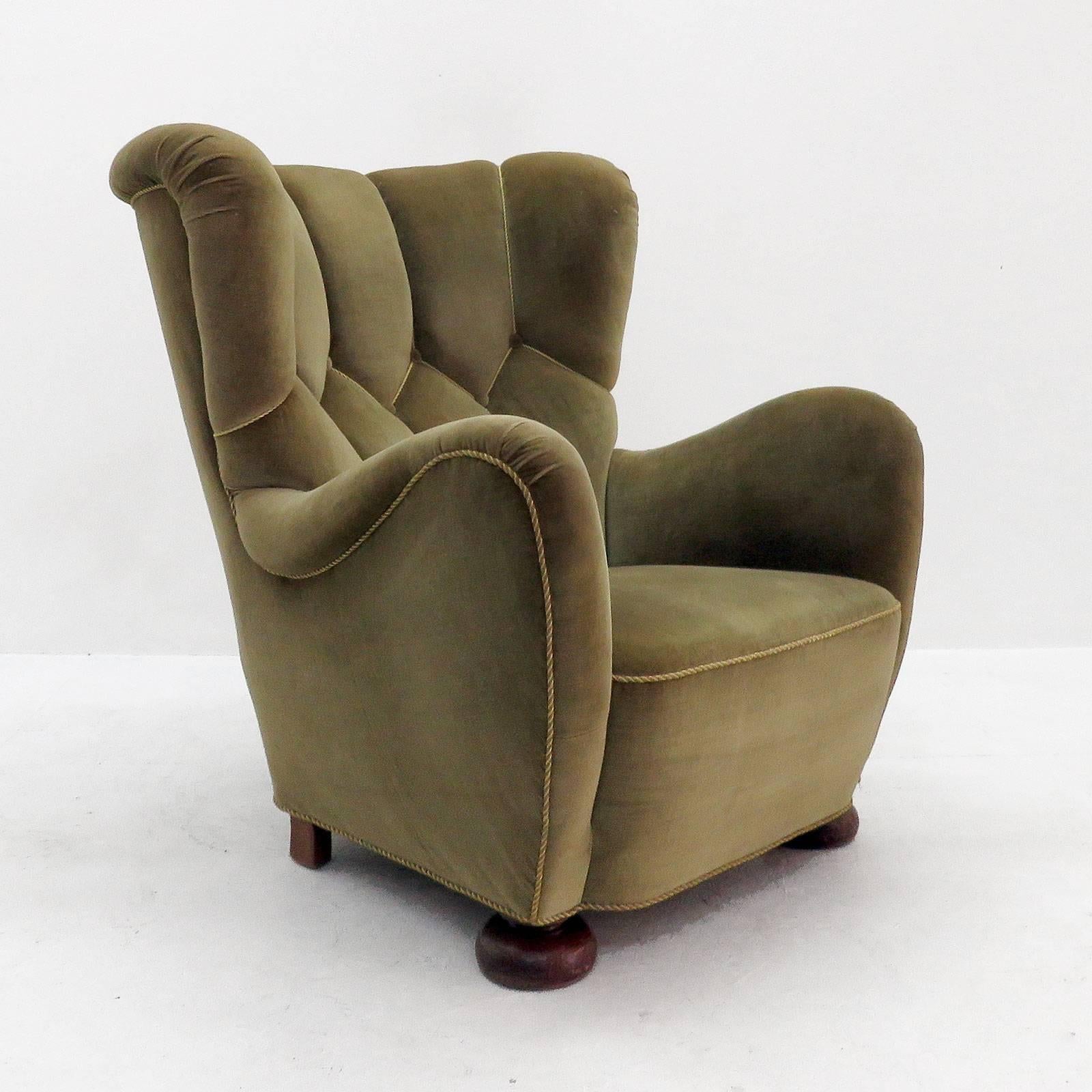 Wonderful, highly comfortable 1950s high back armchair in style and quality of Frits Henningsen, in original mohair upholstery on spring supported seat and tufted, buttoned slightly winged back.