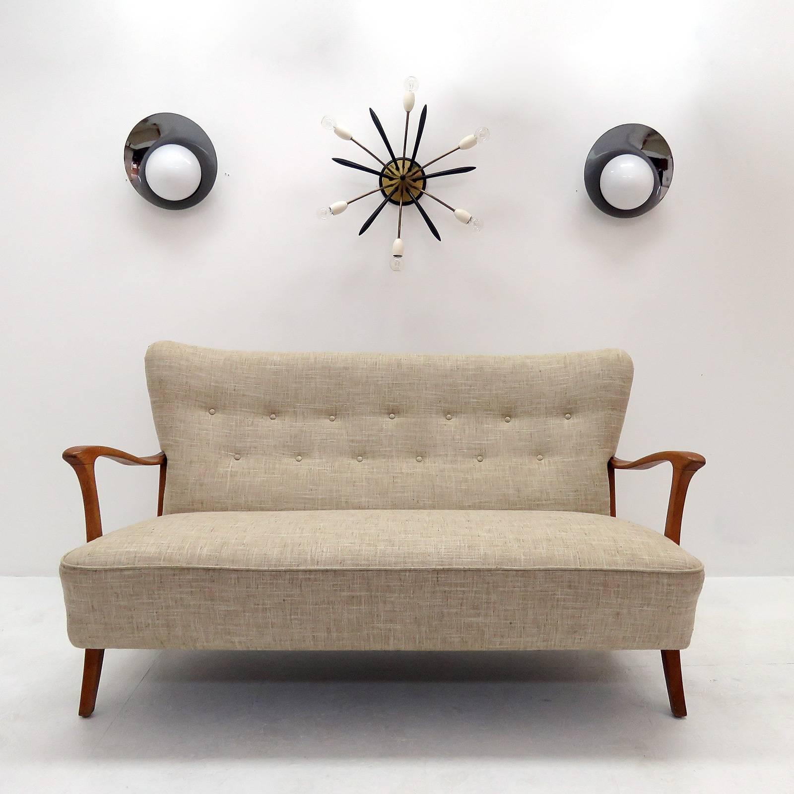 Wonderful three-seat Danish modern sofa in style of Frits Henningsen, patinaed sculptural beech frame with professionally reupholstered body, The concave wing back is tufted and the seat is spring supported.