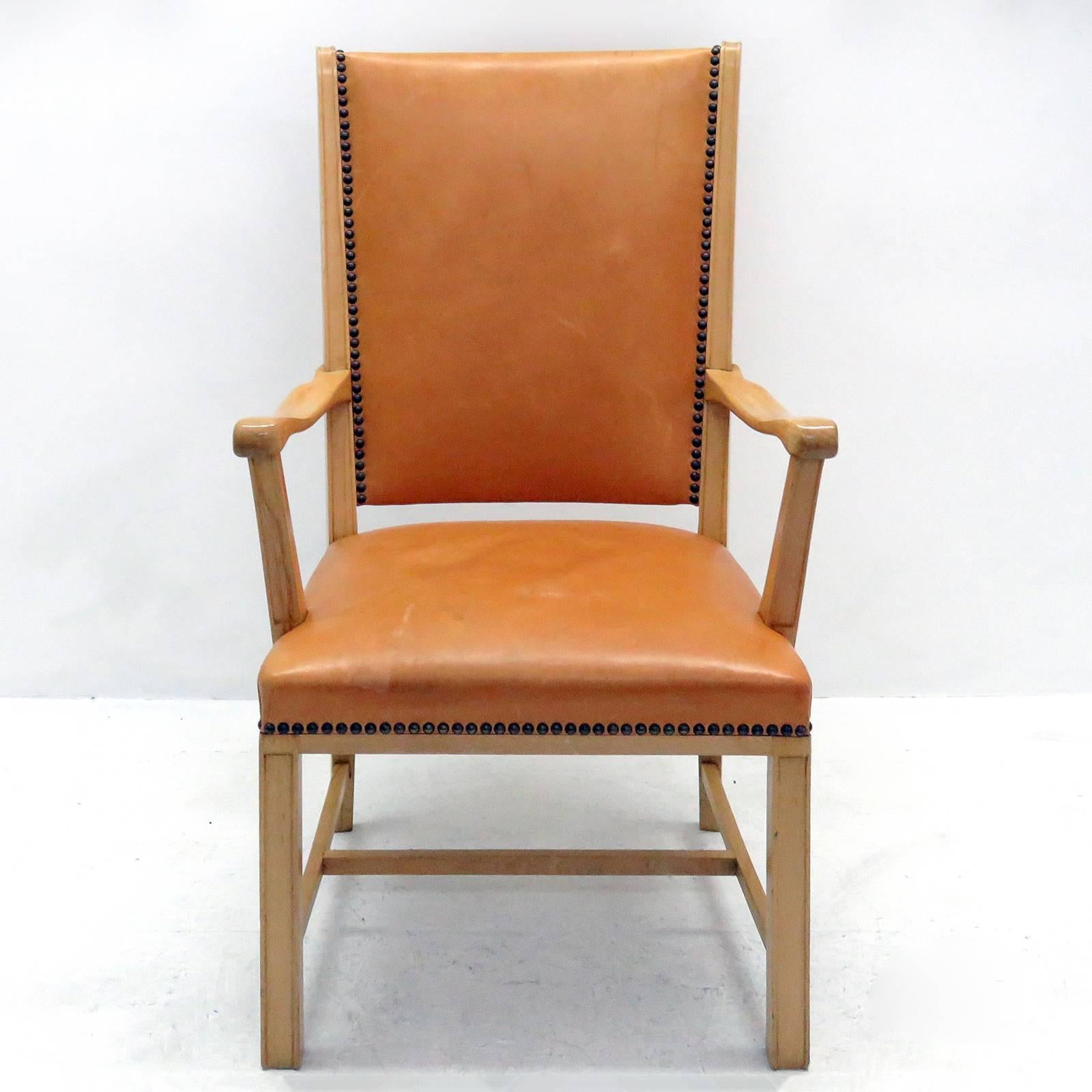 Elegant 1940s Swedish highback armchair in beechwood with cognac colored leather upholstery and brass nailhead trim.