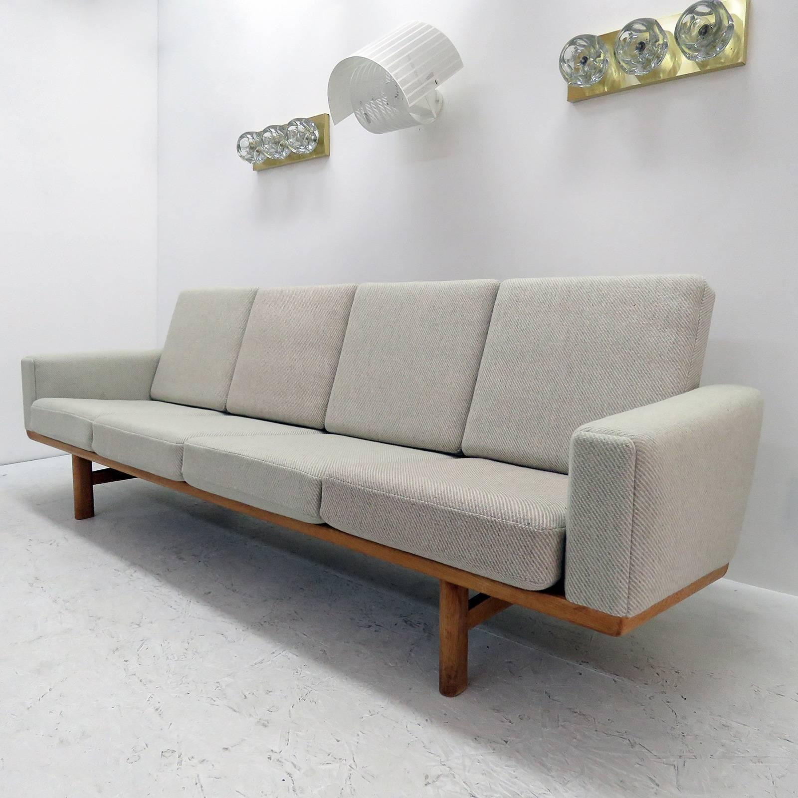 vintage 1950s Danish four-seat sofa, model GE236/4 designed by Hans J. Wegner for GETAMA, solid oak frame with nice patina and original cushions later reupholstered with light wool fabric, marked.