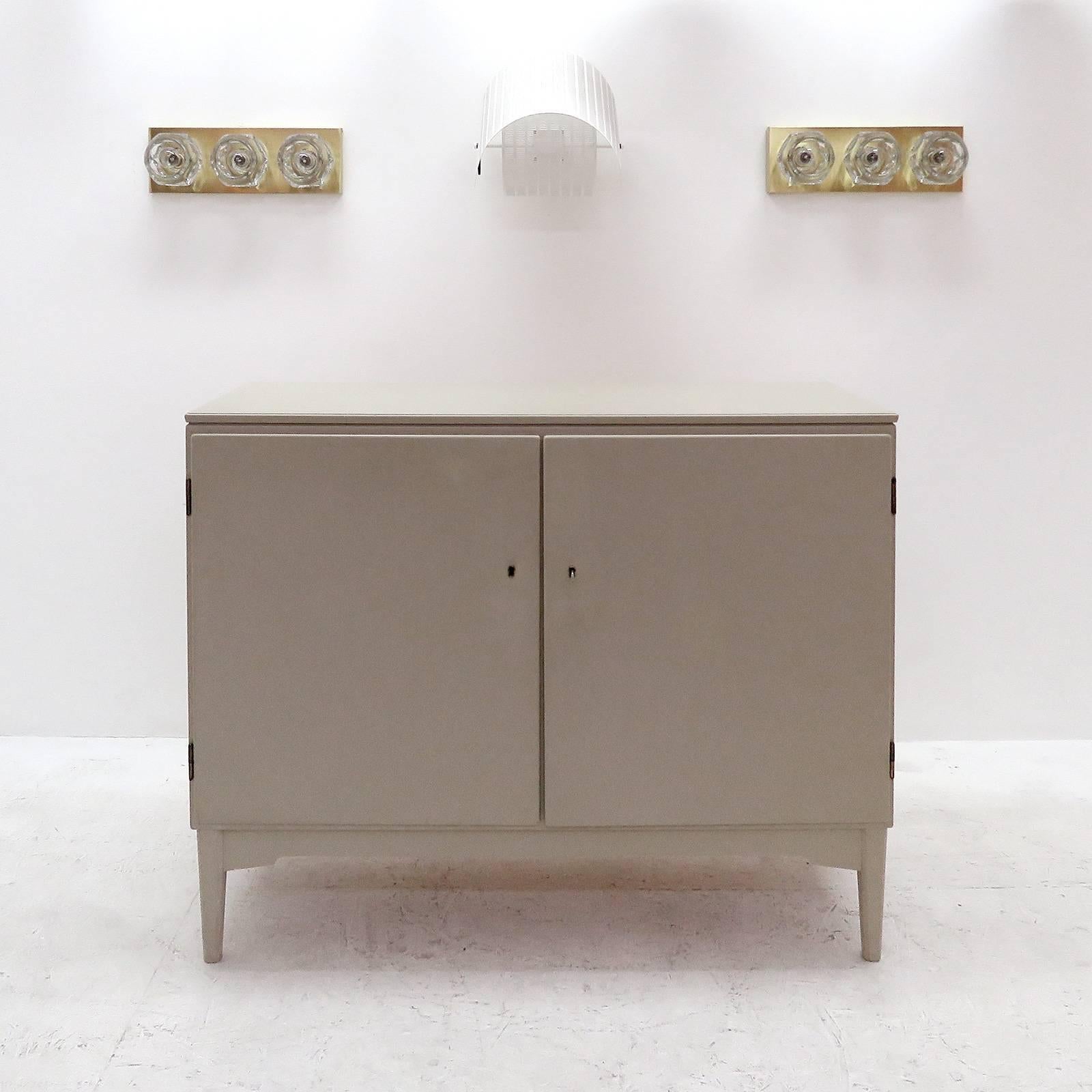 Minimal 1940s Swedish sideboard, painted in light grey with two doors and four drawers on one side and two shelves on the other side, key present.