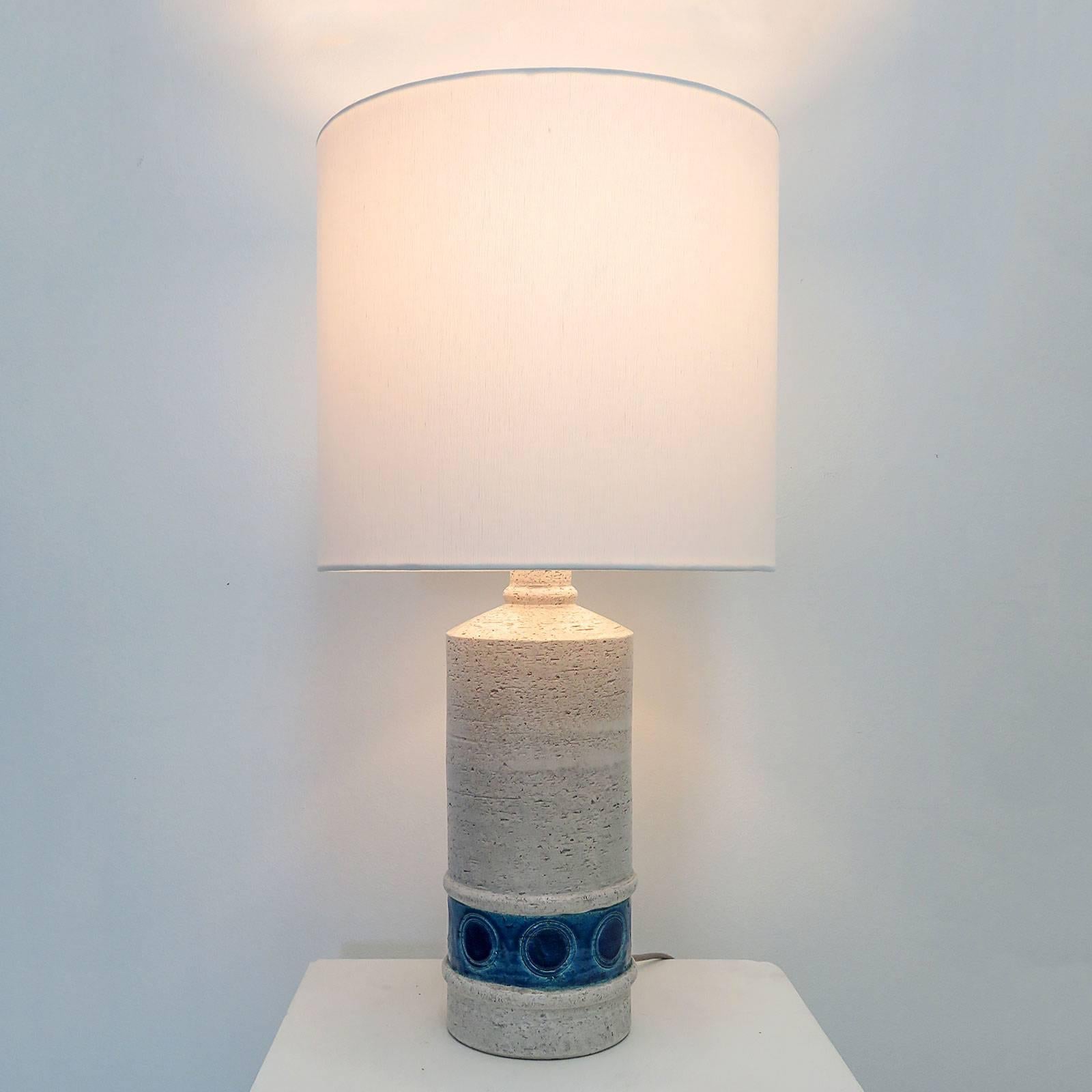 Wonderful pair of glazed ceramic table lamps in a textured, off-white color with a lower band of light and dark blues highlighting incised geometric decorations. Designed by Aldo Londi for the collection 