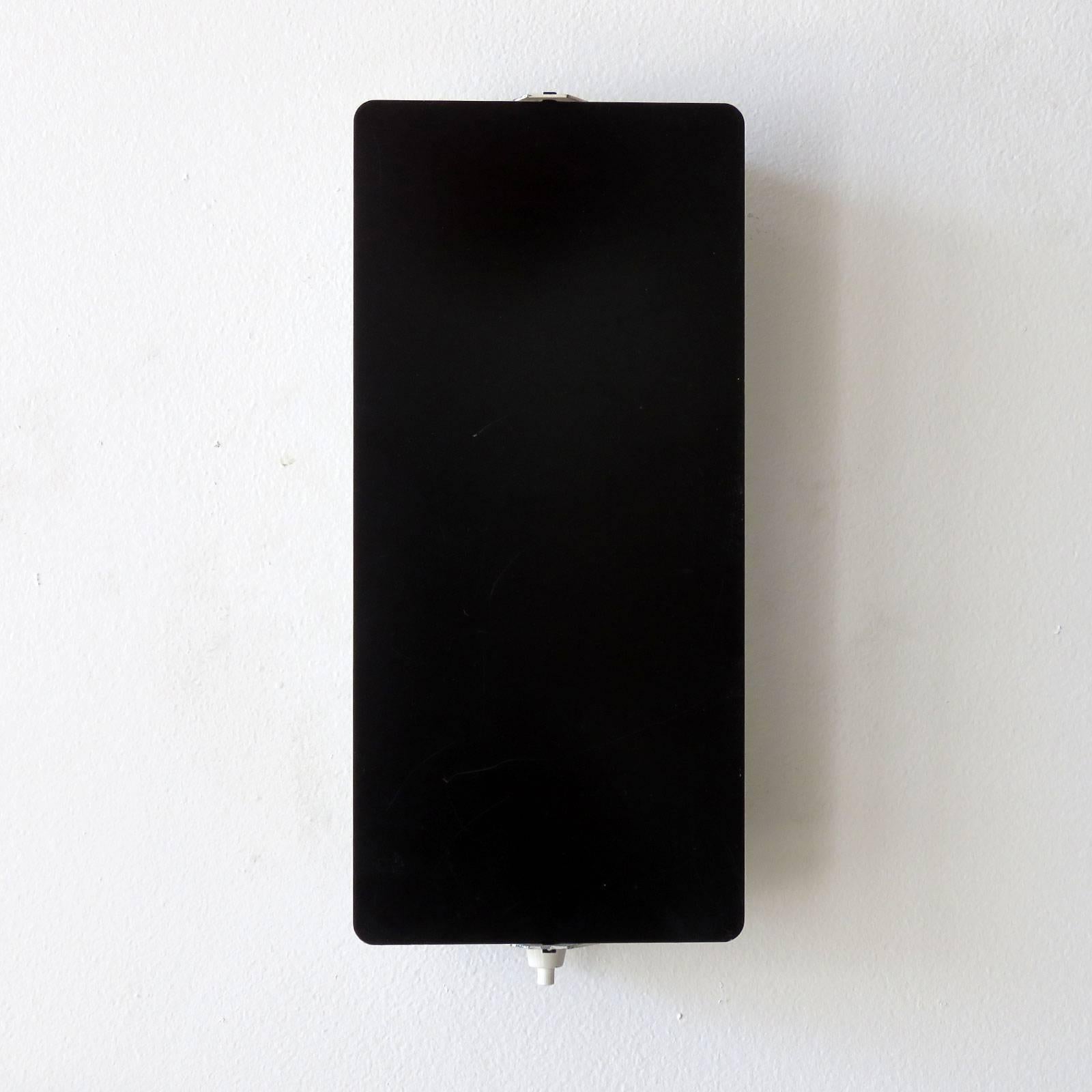 Rare large scale enameled wall lights by Charlotte Perriand with adjustable reflectors in black enameled finish with two sockets each, optional horizontal or vertical mount, manufactured and distributed by Steph Simon, Paris, marked. Priced