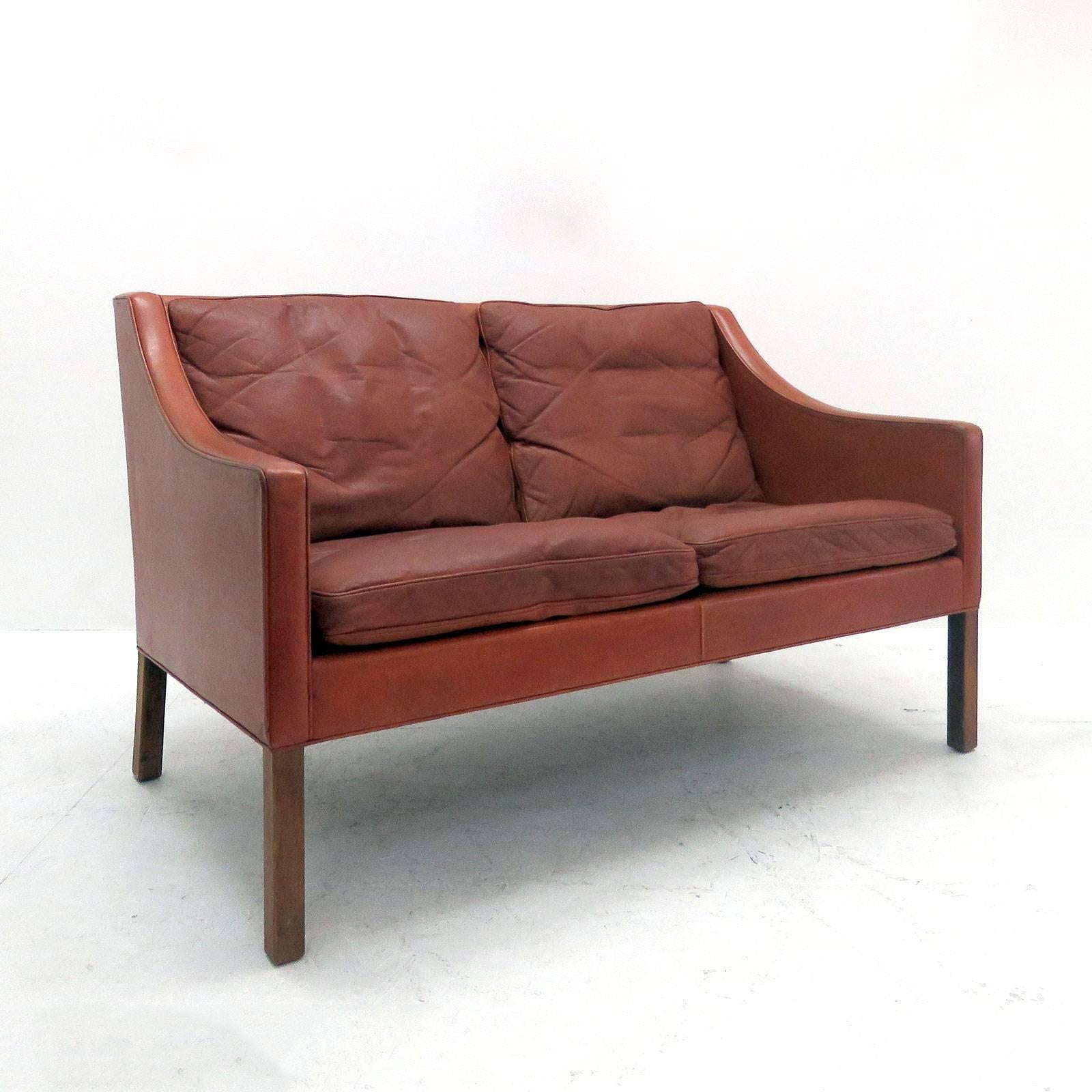 Stunning two-seat sofa model no. 2208, designed by Børge Mogensen in 1963 and produced by Frederica Stolefabrik, Denmark, in red cognac colored leather on mahogany legs with loose down cushions.