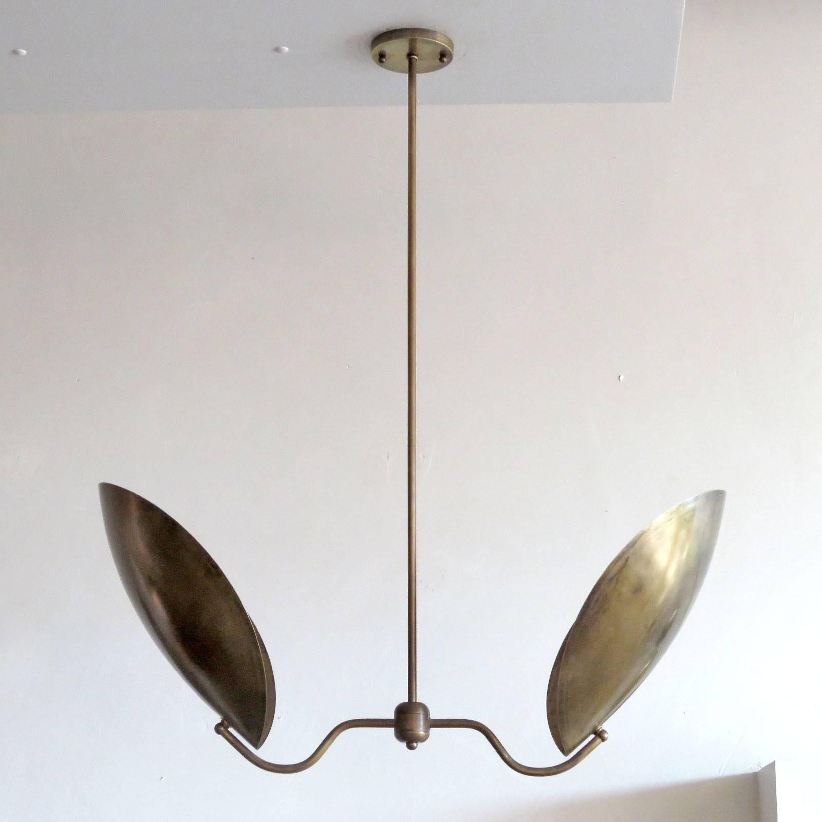 Elegant two shield pendant 'Chiton-2' by Gallery L7, reminiscent of stag beetle armor, in a raw brass finish, overall height can be customized. Two E26 sockets per fixture, max. wattage 60w each, wired for US standards or European standards