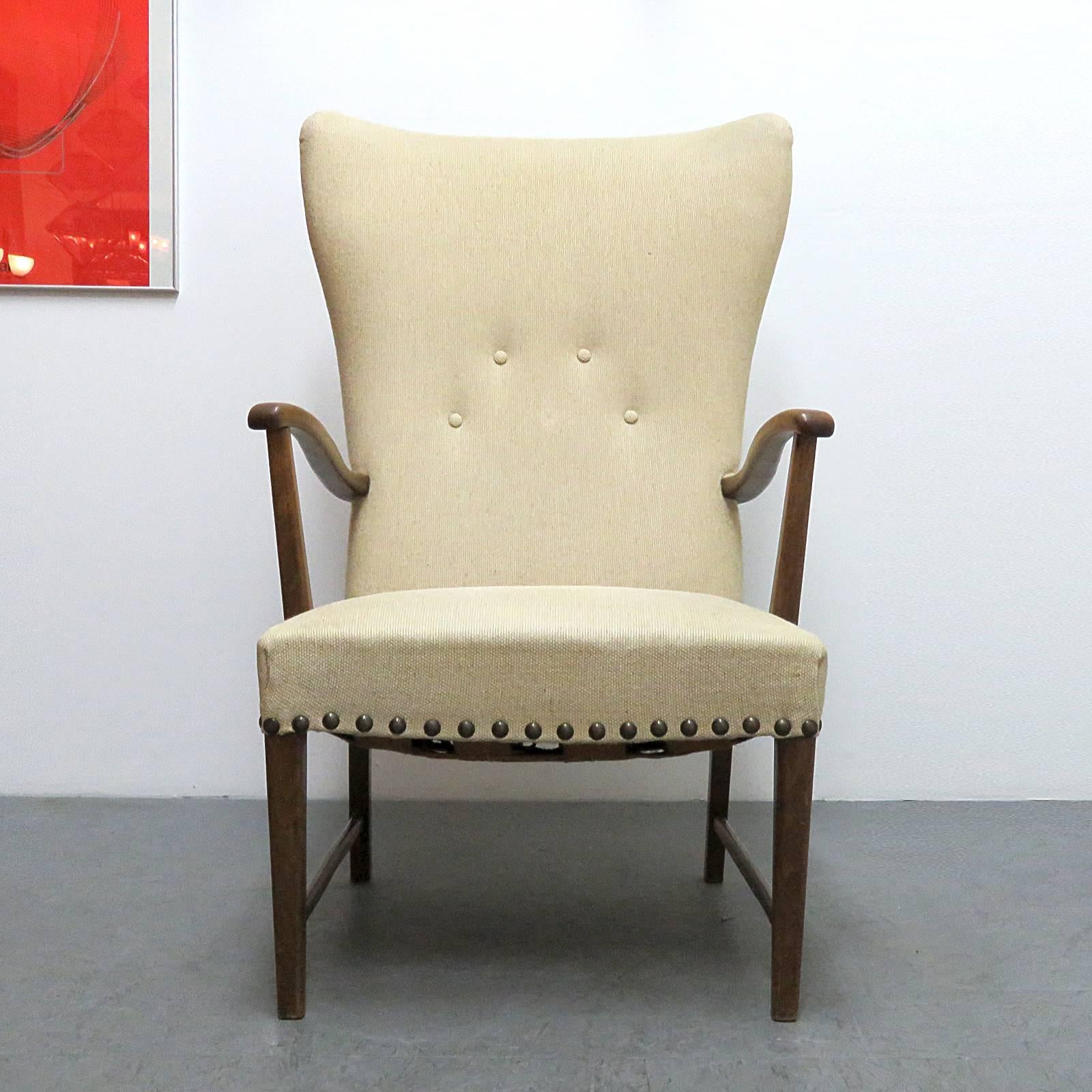 stunning 1940s Danish Mobler wing back lounge chair, oak frame with sculptural arms and original sand color wool upholstery with brass nail head trim, backrest tufted with four (originally five) covered buttons