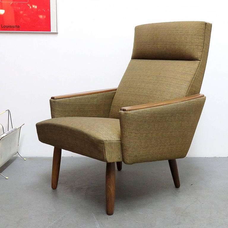 great 1960's Danish high back lounge chair in greenish, slightly patterned original fabric with teak legs and armrest covers