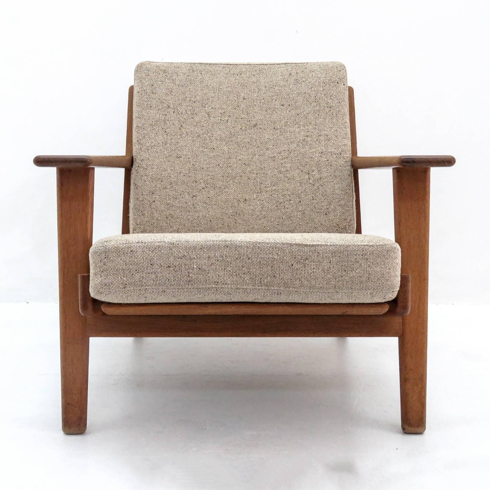 Wonderful lounge chair GE-290, designed by Hans J. Wegner for GETAMA in 1953, solid oak frame with nice patina and upholstered in beige gray wool on original spring cushions, marked.