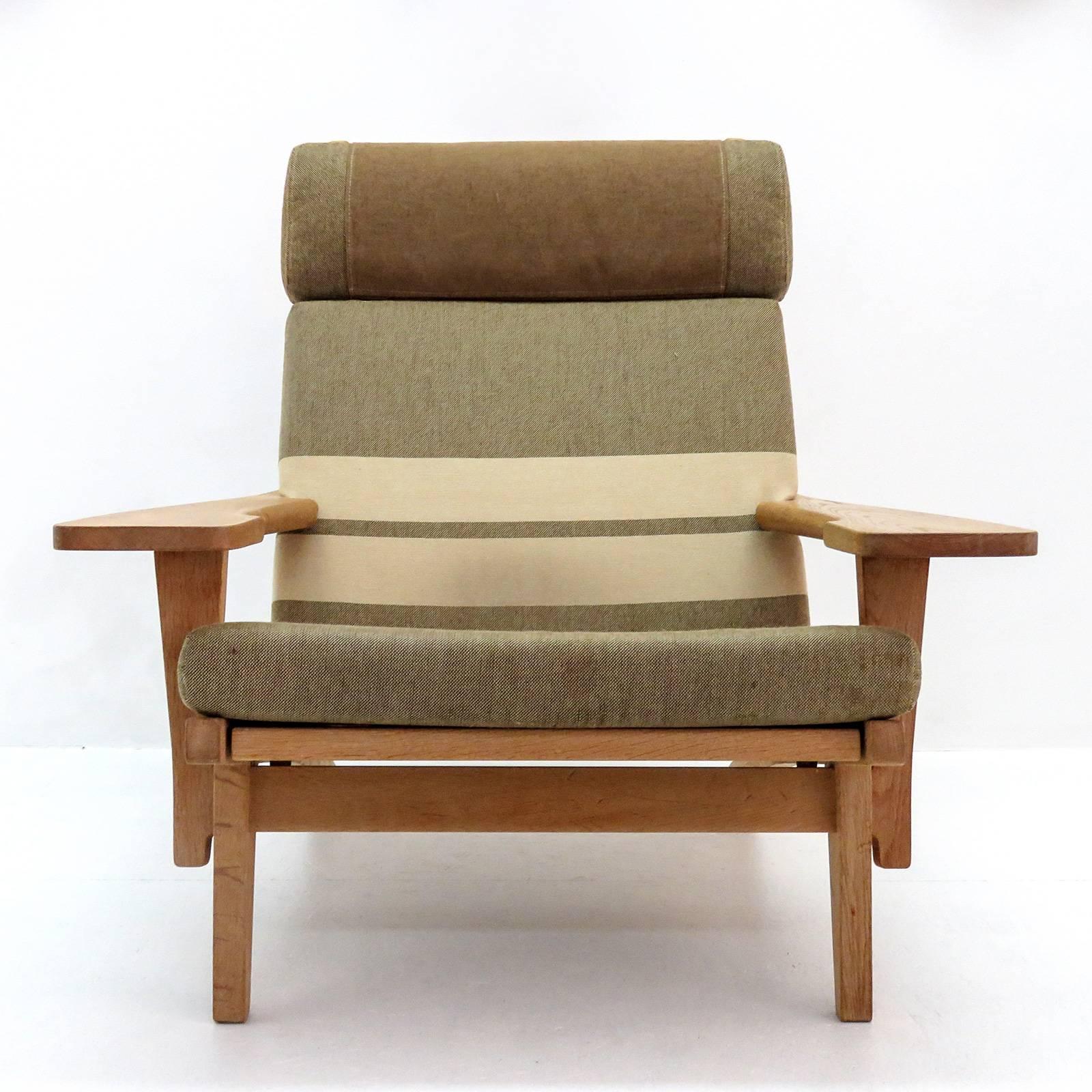 Large-scale high back armchairs by Hans Wegner with solid oak frame and original cushions in greenish striped wool, produced by GETAMA in 1969, model GE 375, detachable neck cushion, original makers mark to underside.