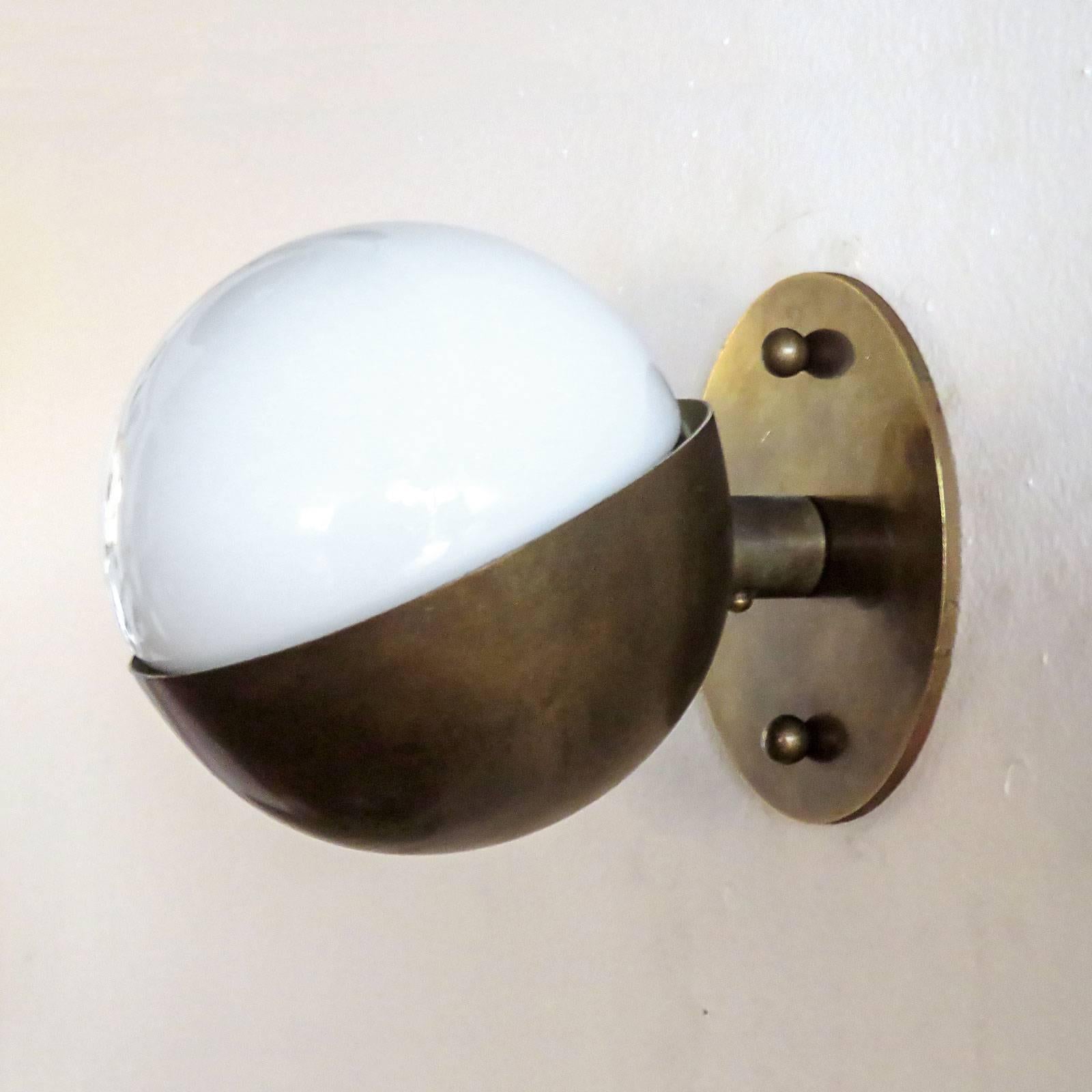 Remarkable small 'Radiohuset' wall light, by Vilhelm Lauritzen for Louis Poulsen, in patinaed brass and opaline glass designed in 1931 for the Broadcasting House in Copenhagen.
  