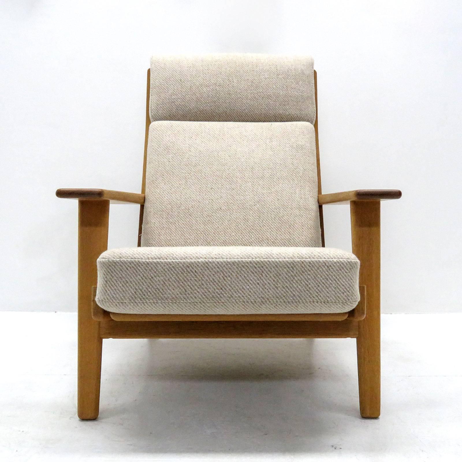 Wonderful high back lounge chair ‘GE290’ by Hans J Wegner for GETAMA with matching ottoman ‘GE290’ A, solid oak frame with nice patina and original cushions upholstered with light wool fabric, marked, measurements for chair only, measurements