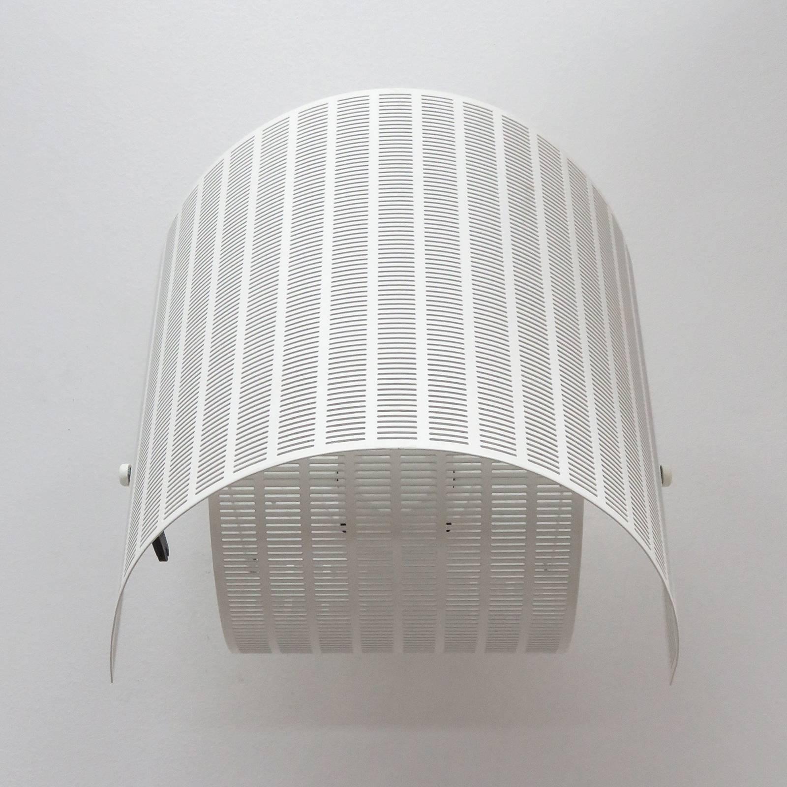 Sculptural wall lamp, model 'Shogun Parete', was designed by Mario Botta for Artemide in 1986 in Italy. Comprised of two perforated, adjustable shade elements reminiscent of Japanese head wear, marked.