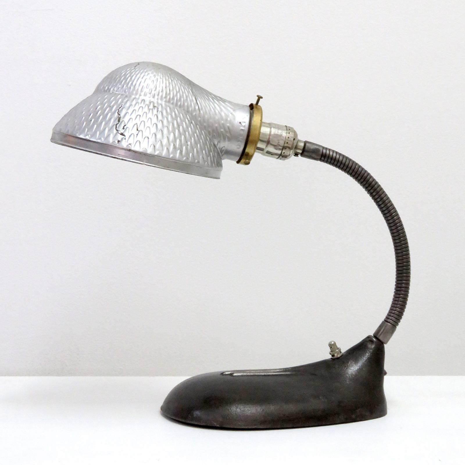 Striking mercury glass shade table lamp with goose neck arm and oversized steel base, new socket and brass shade holder.