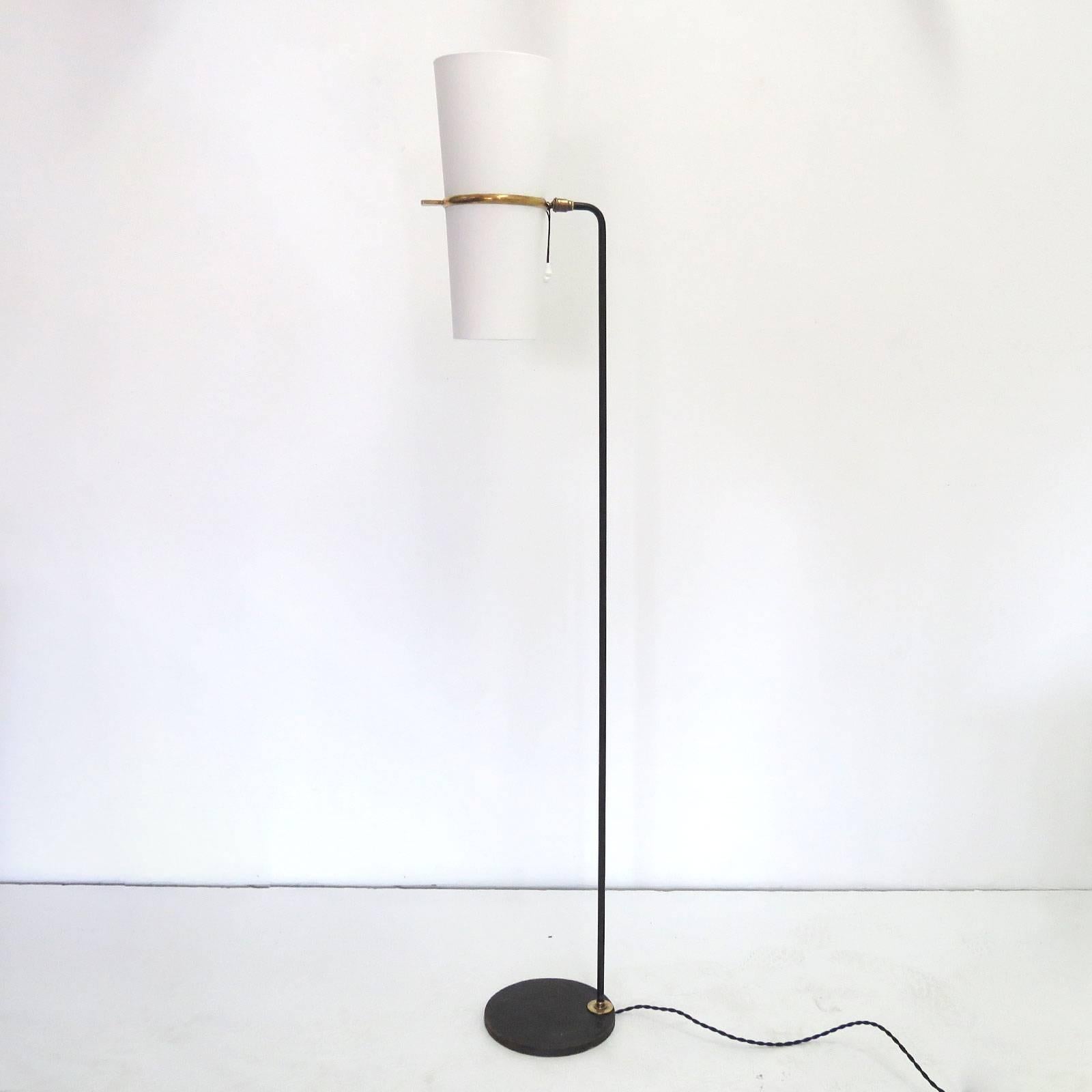 Elegant 1950s floor lamp by the French company Maison Lunel with a white silk double rotary shade, a round blackened steel base, post and brass details. The shades are newly mounted onto the original frames. The light is fully adjustable due to a