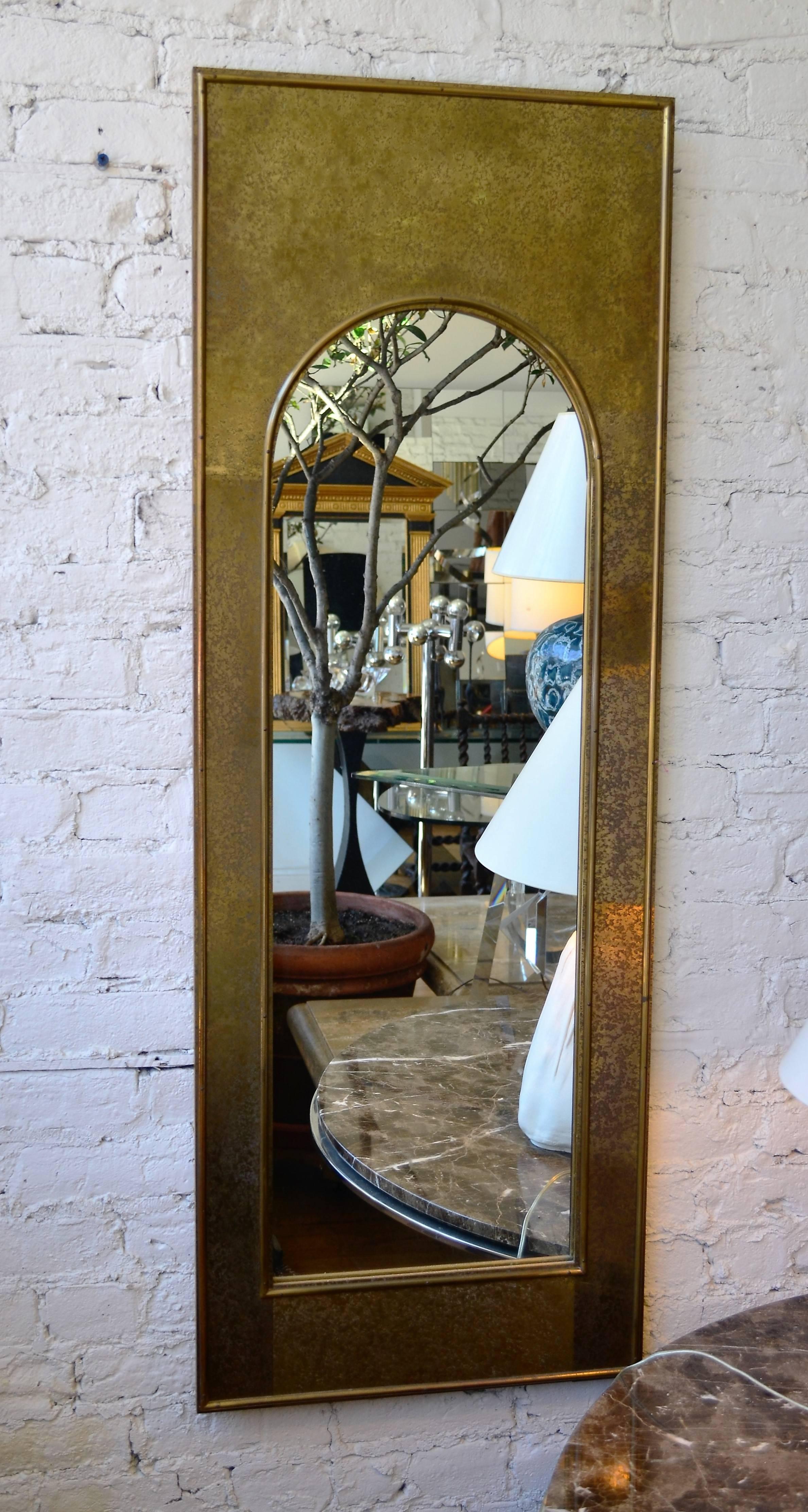An elegant brass clad Midcentury Mastercraft mirror with an arched top.