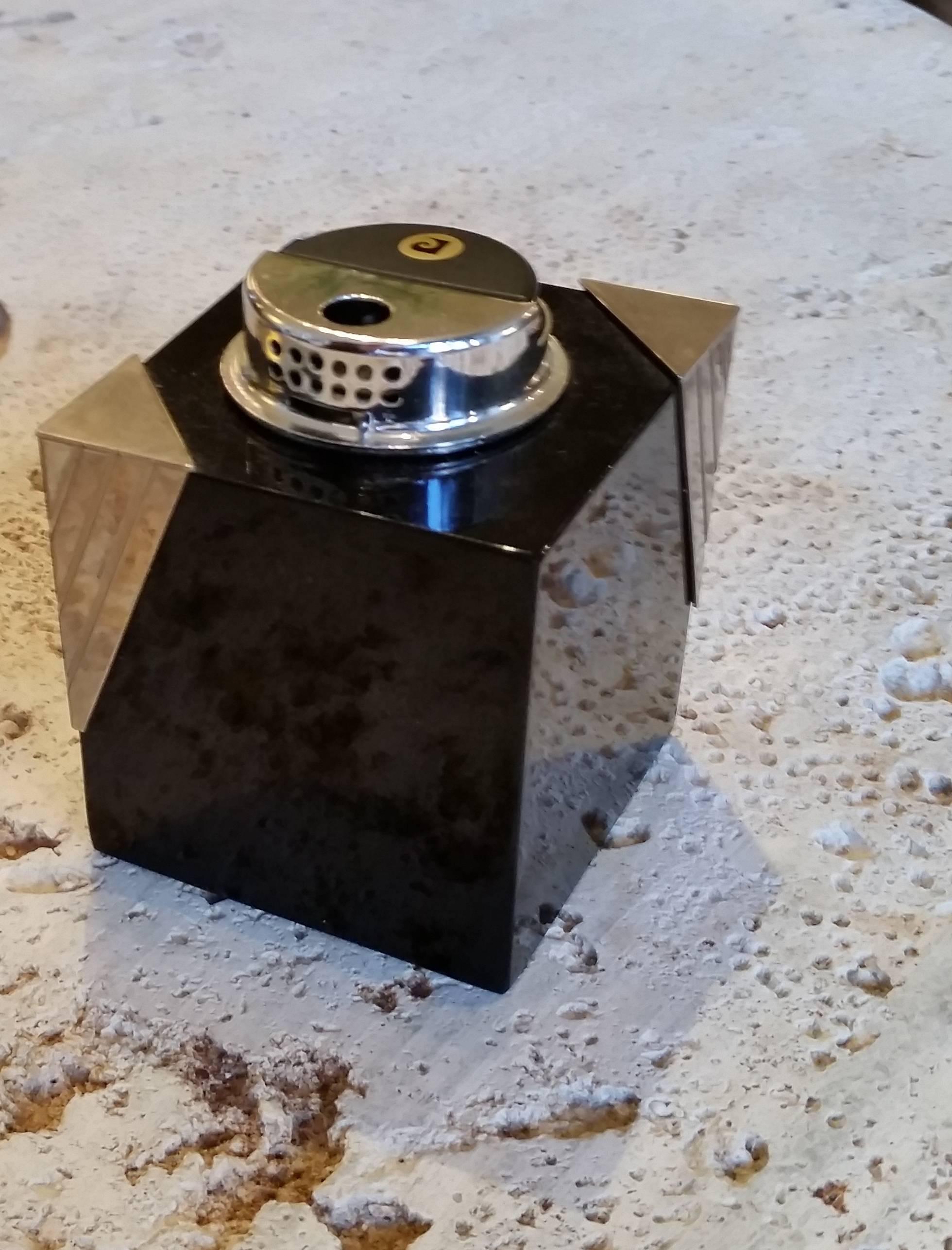 
A fantastic Pierre Cardin tabletop lighter. 
The lighter is fashioned out of a single block of
jet black glass with chrome triangle corner mounts.
 