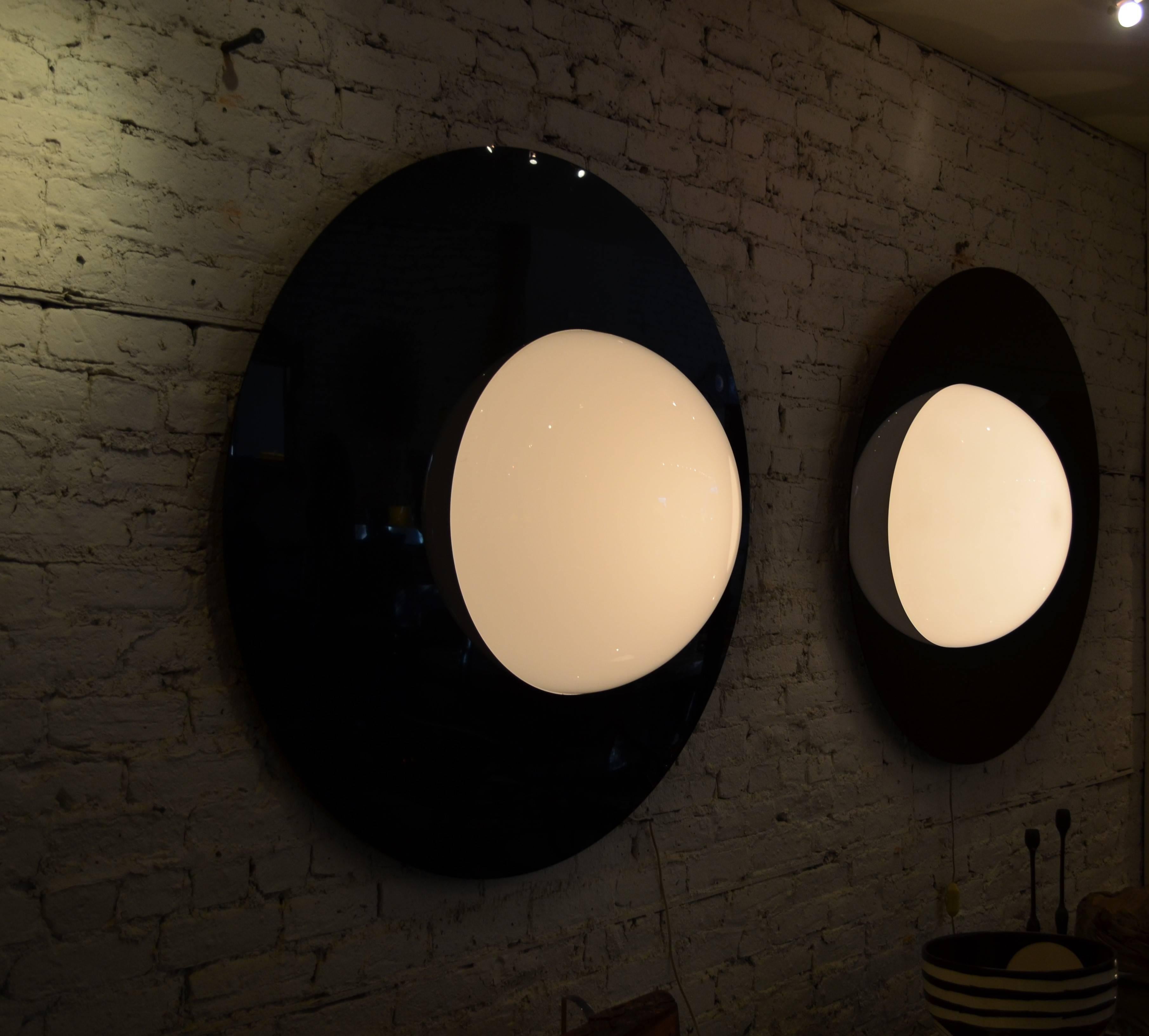 Incredible eye candy on a monumental scale.
A pair of acrylic graphic black and white mod sconces.
Each sconce has a 46 inch black plastic back disk.
An off-centre 20 inch white translucent half globe
projects 10 inches from the wall. The