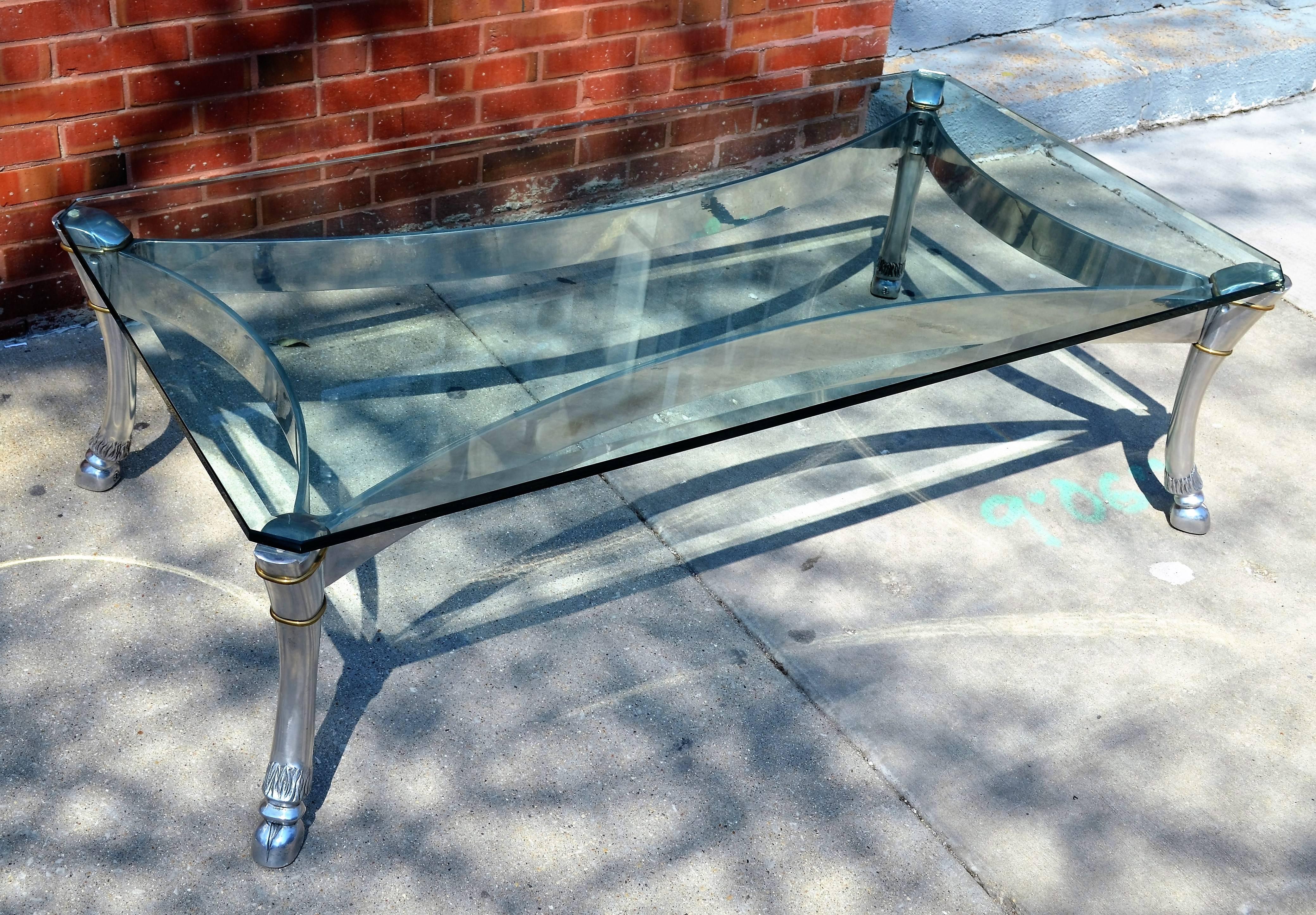 An exceptionally well crafted  large-scale steel and glass coffee table.
Elegant metal table with large scale hoofed  legs.
The beveled glass top is original and is quite thick.
The coffee table is in the manner of Arthur Court.