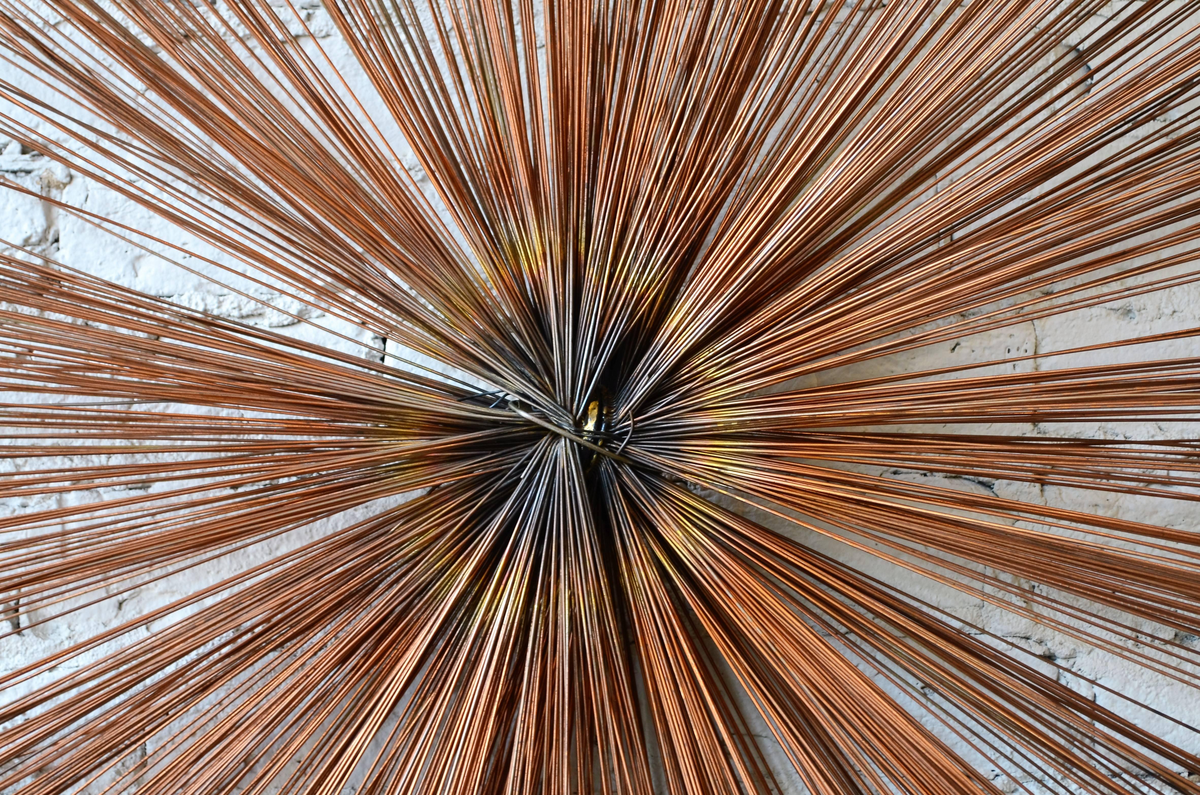 Starburst wall sculpture.
Unlike its Curtis Jere starburst counterparts, this piece is comprised
of multiple concentric layers of metal spokes. It has a dark bronze patina
finish. Outstanding quality.