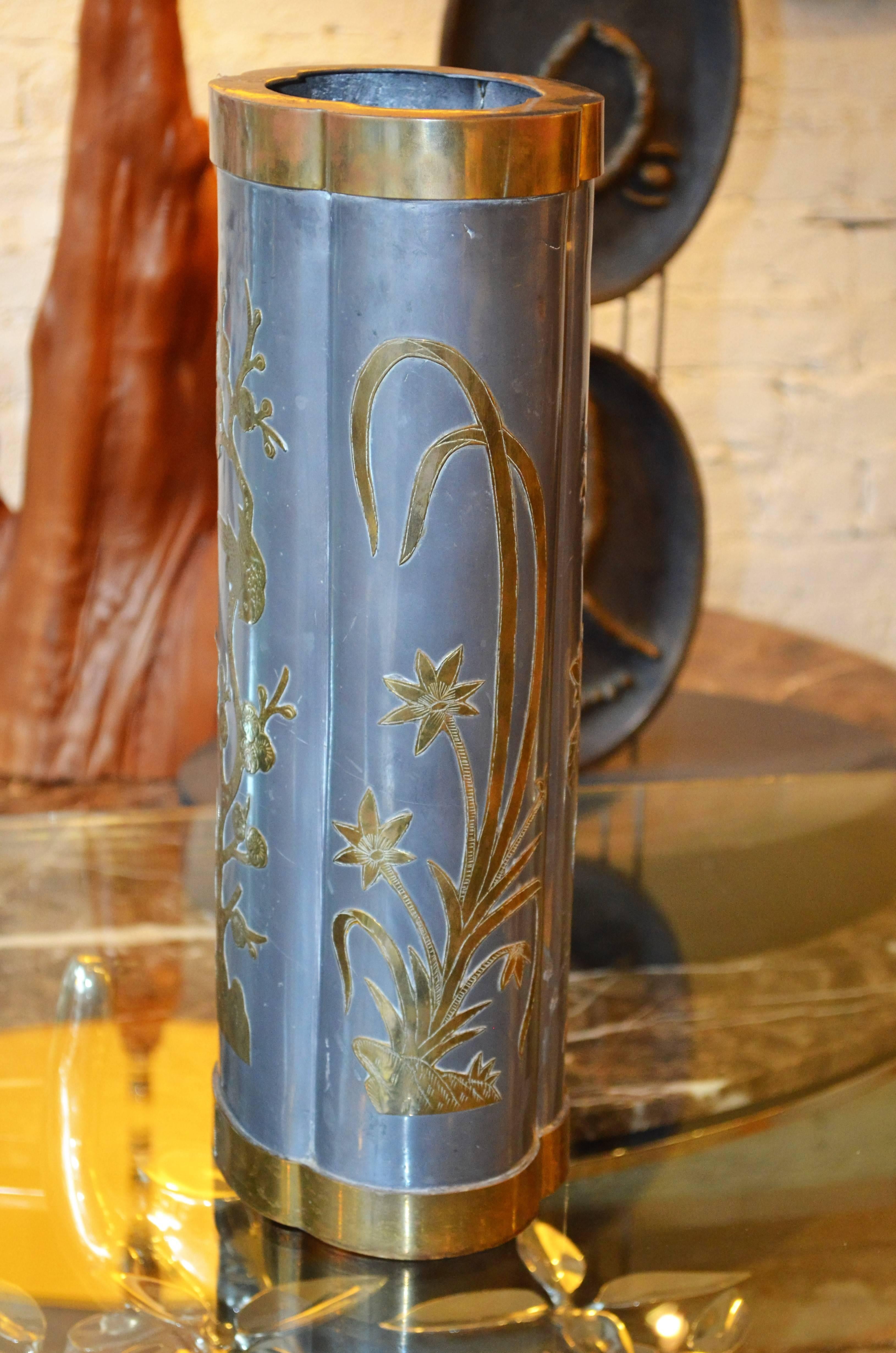 An Asian inspired pewter vase accentuated with Chinese floral images
in applied brass. Age appropriate wear to the metal. Please see images.
Great as an umbrella stand. Stamped made in Hong Kong to the
bottom.