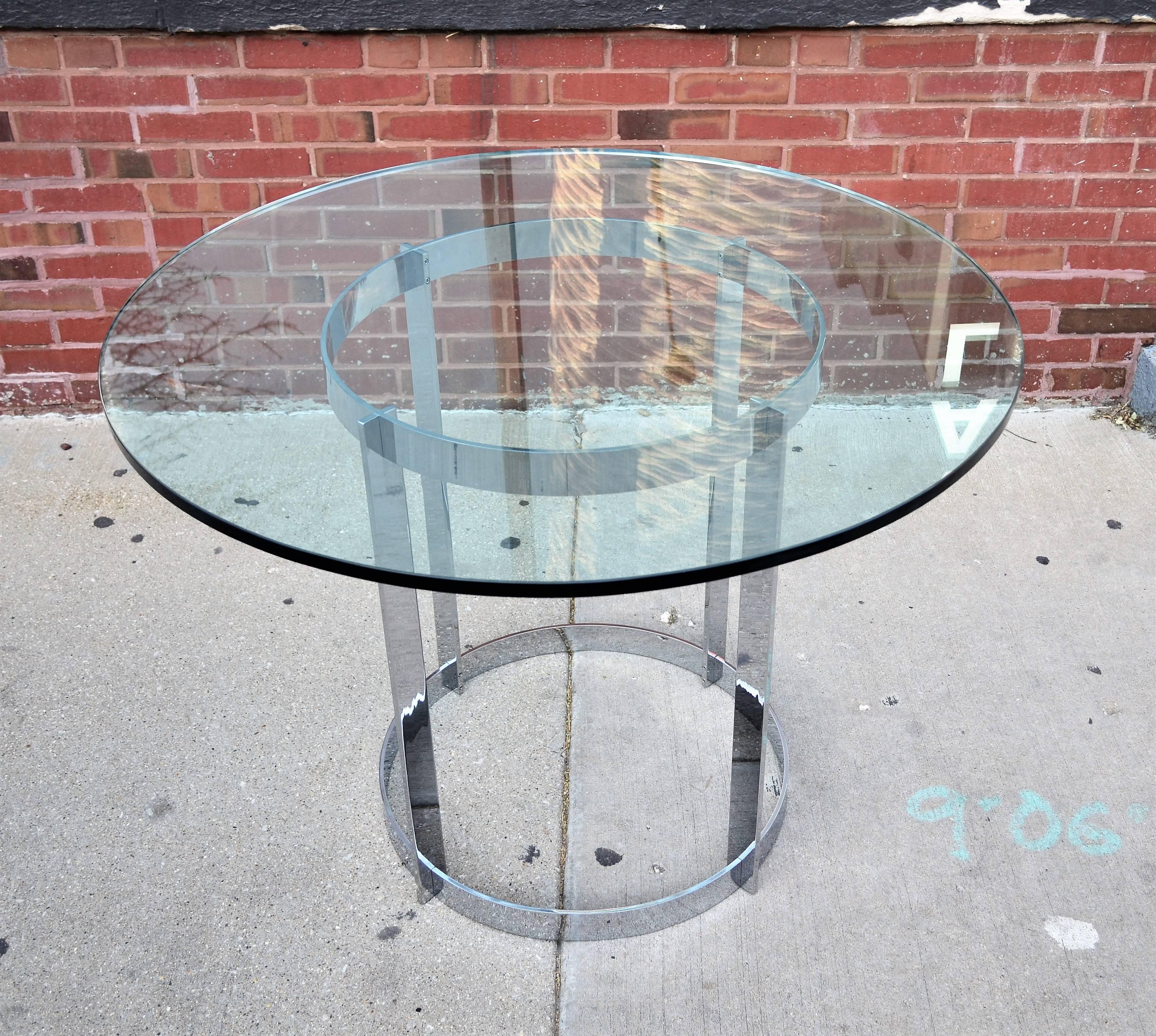 A well made heavy solid chrome by Tri-Mark round dining table with a thick glass top.
Its modern Minimalist design and versatile size lends itself to multiple uses.
Side or end table, center table or even a games table. 
