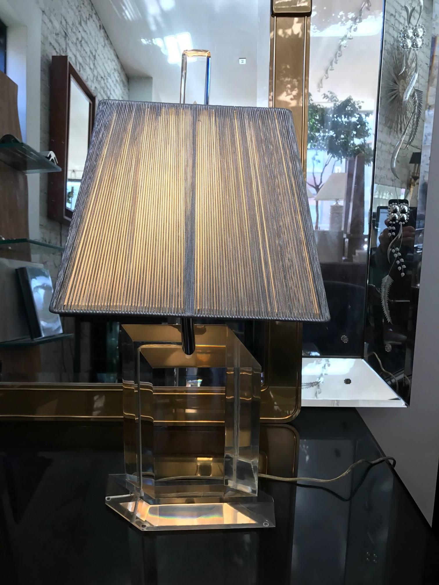 Lucite Les Prismatiques Mid-Century  lamp. Scuptural from every angle. The lucite is crystal clear. The cord runs down the side in a carved out channel. Included is the lamps original silver thread rectangle shade.