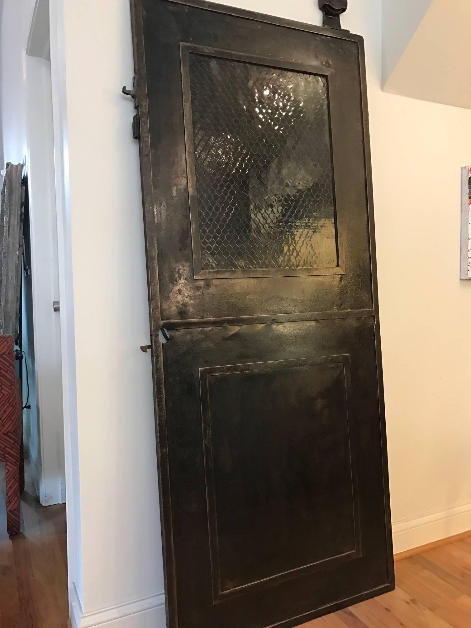 A polished Industrial metal fire door with safety glass. The door was manufactured by Harris & Reed in Chicago. Wonderful in a Steampunk interior.