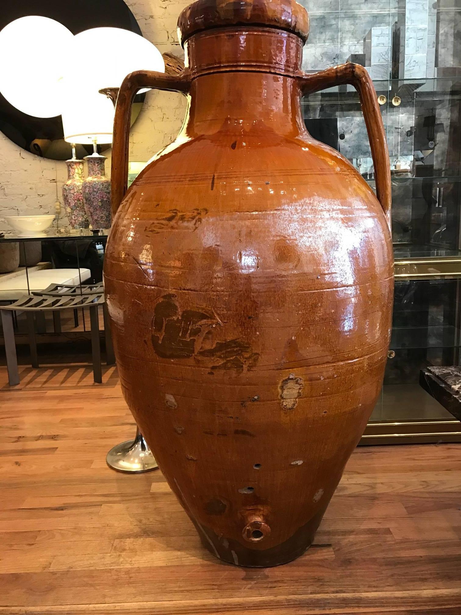 Large Italian Amphora form olive oil vessel. The 19th Century large vessel has a rich glazed terra cotta finish. There is a spout at the base.
