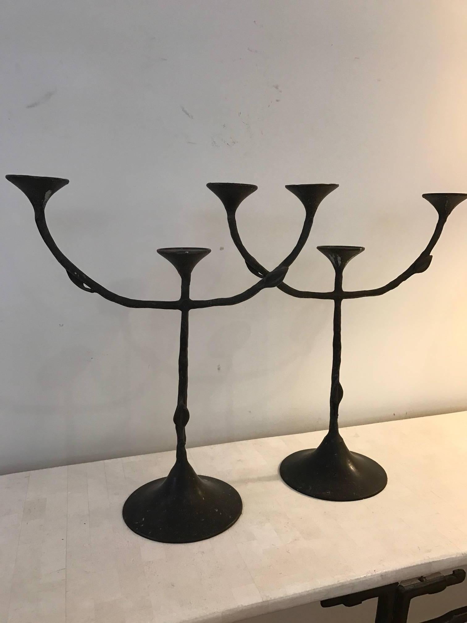 A pair of hand-wrought bronze three-arm candlesticks in the manner of Giacometti.
The arms and the base have an applied iron leaf decoration.