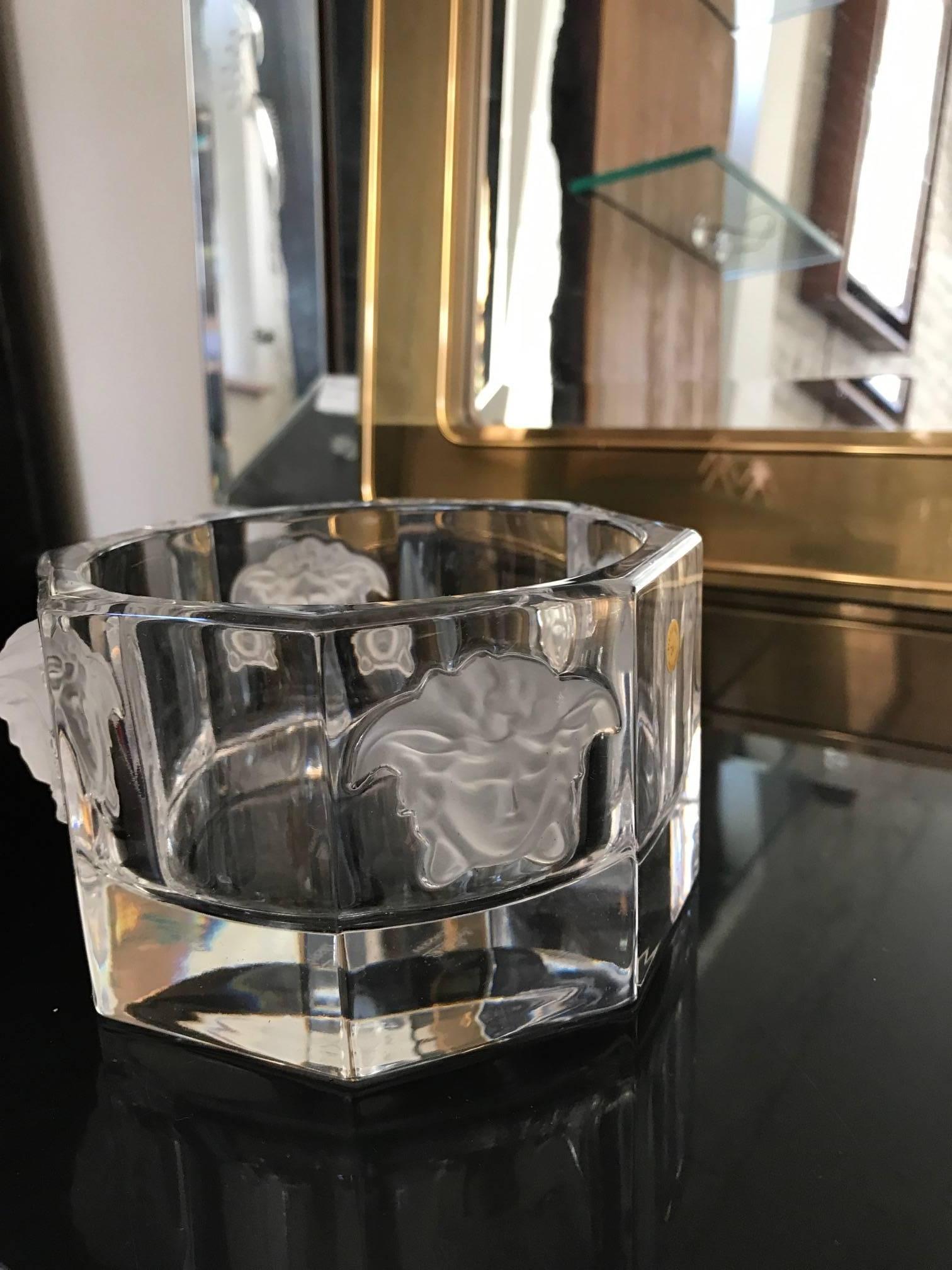 A glass octagon shaped glass bowl by Versace for Rosenthal. The decorative object is clear glass with four frosted Medusa heads on the sides.