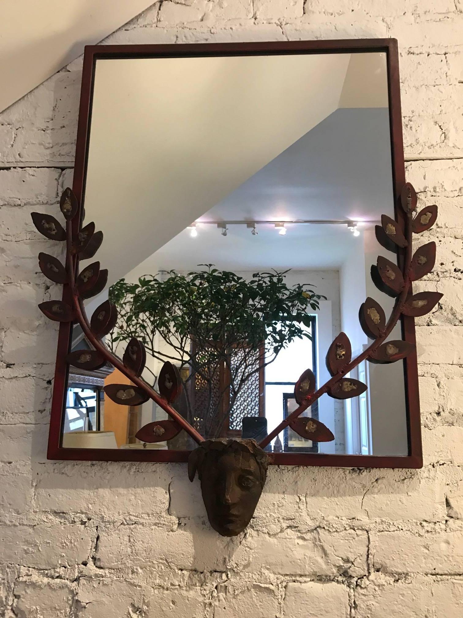 Giacometti style steel mirror with Medusa head and stylized laurel leaf branches.