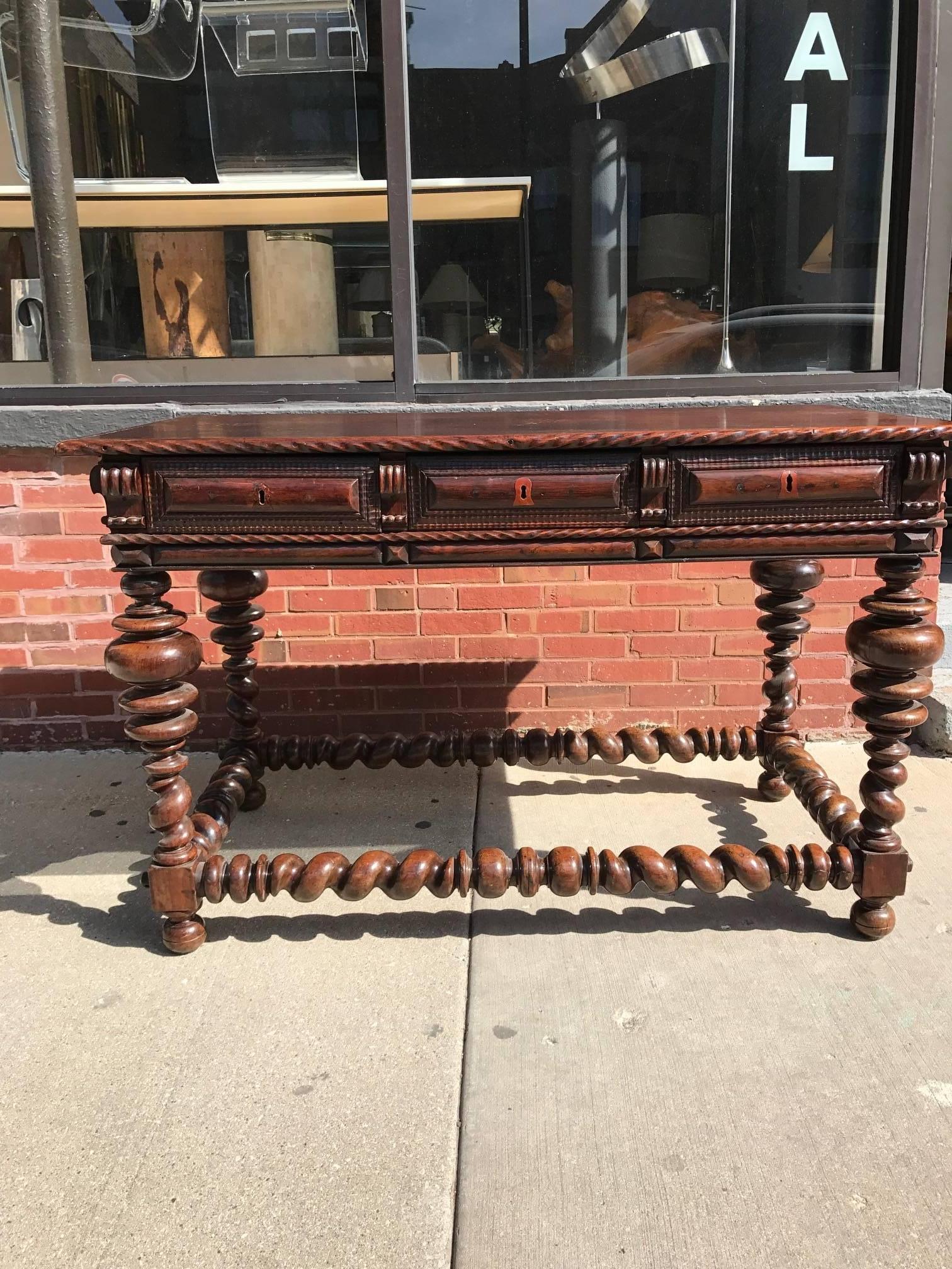 Portuguese rosewood 18th Century console table. This Baroque Portuguese Mesa Butte table has large bulbous ring turned legs. Its turned barley twist stretchers have carved opposing spiral turnings. The table has three drawers with keyholes. There is