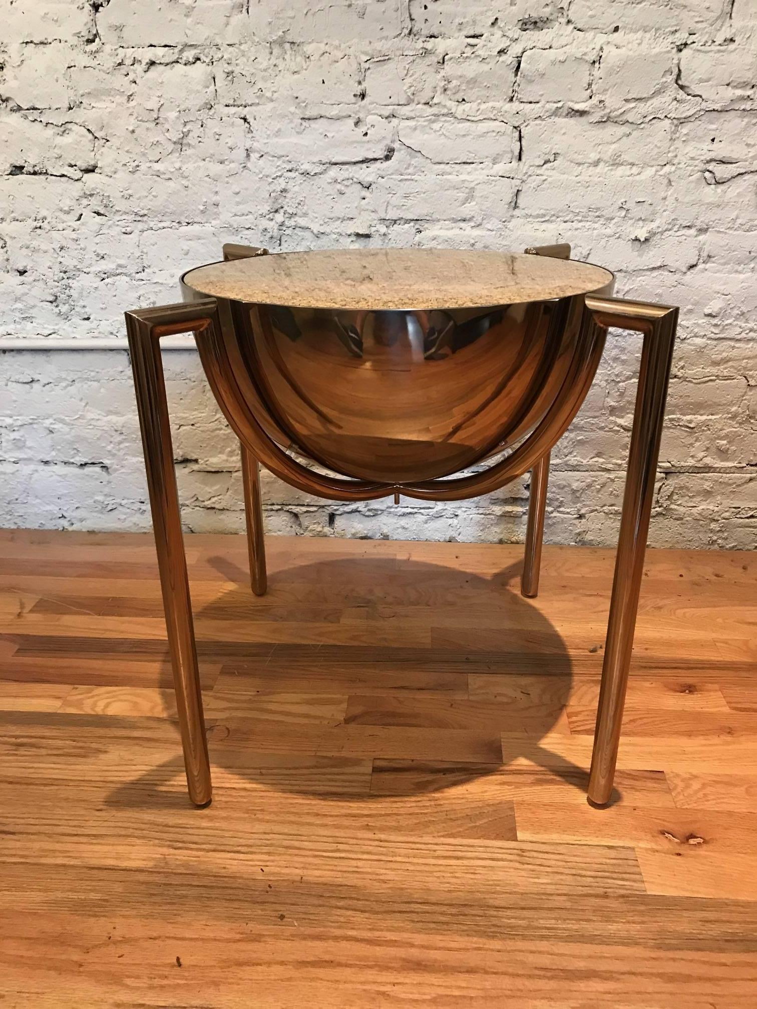 An occassional end or side table designed by J Wade Beam for Brueton. The table has a polished bronze finish over stainless steel. Its top is granite with a beveled edge. First rate quality and seamless construction.