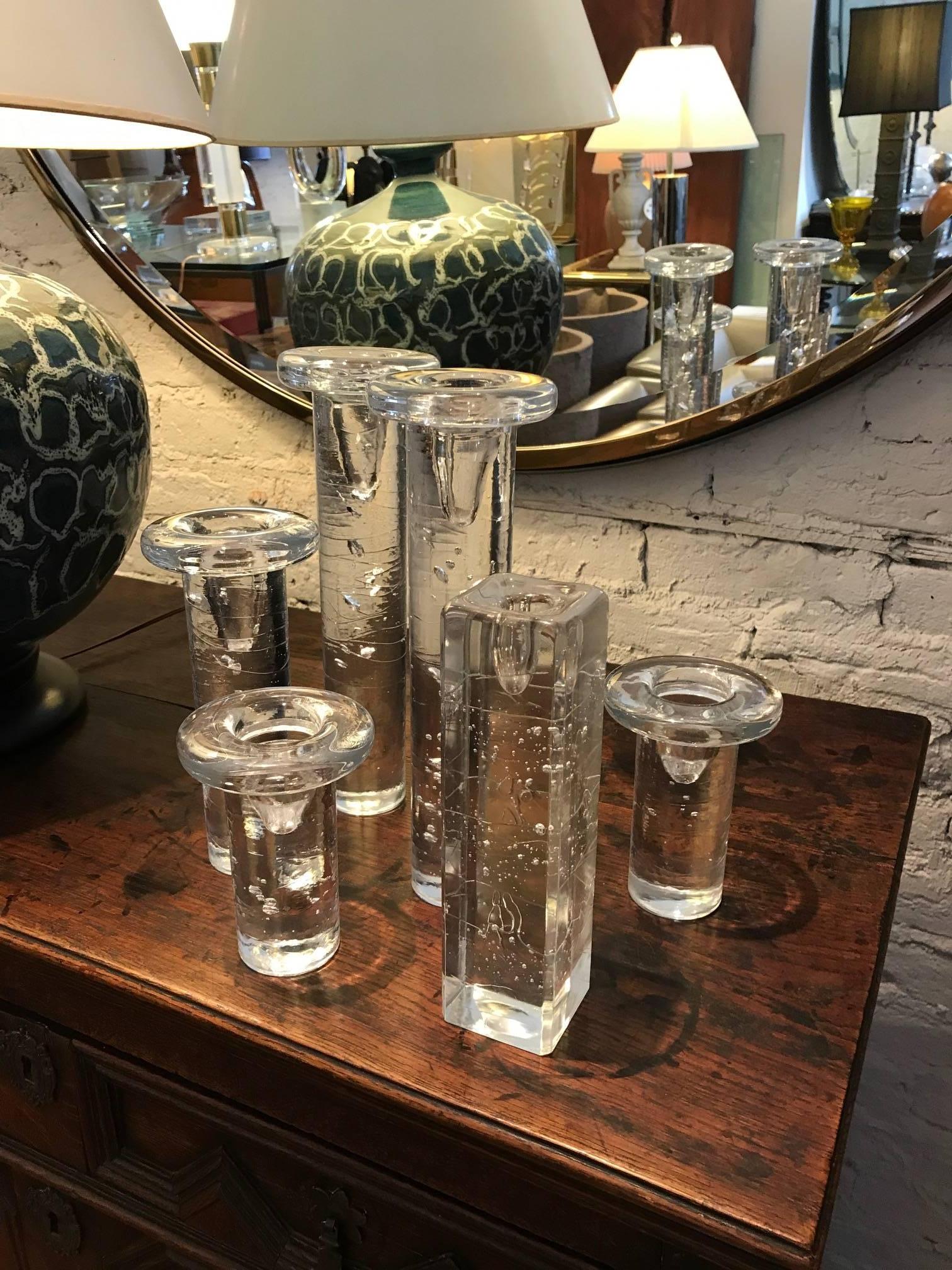 Six clear glass Kosta Boda candle holders. The candle sticks all have free-form bubble inclusions.
Five of the decorative objects are column-form and one is cube shaped.
The height of the candle holders are 12.9, 5.5 inches.