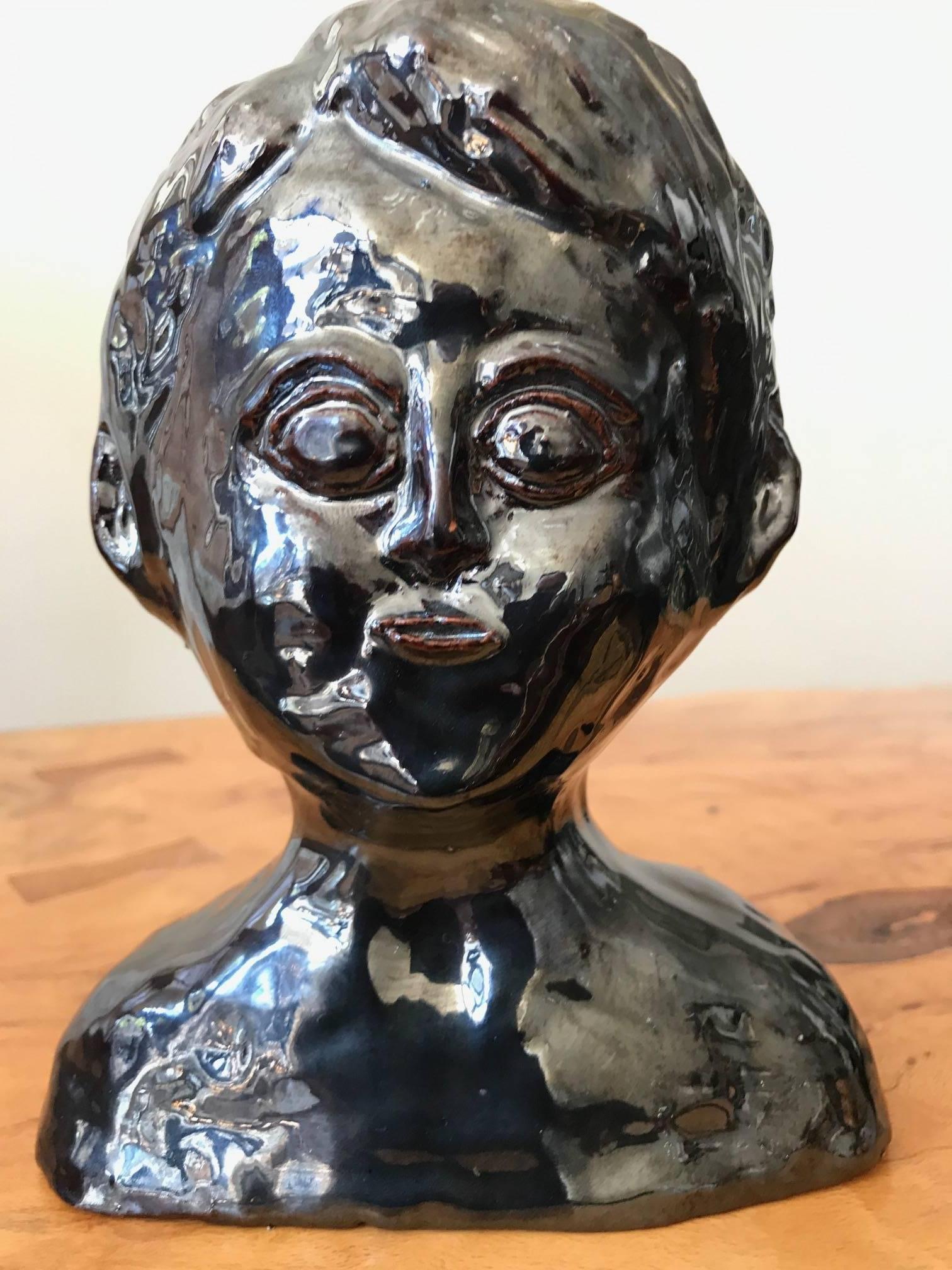 An interesting midcentury tabletop glazed metallic ceramic bust. This decorative object
in not signed though is dated 1967.