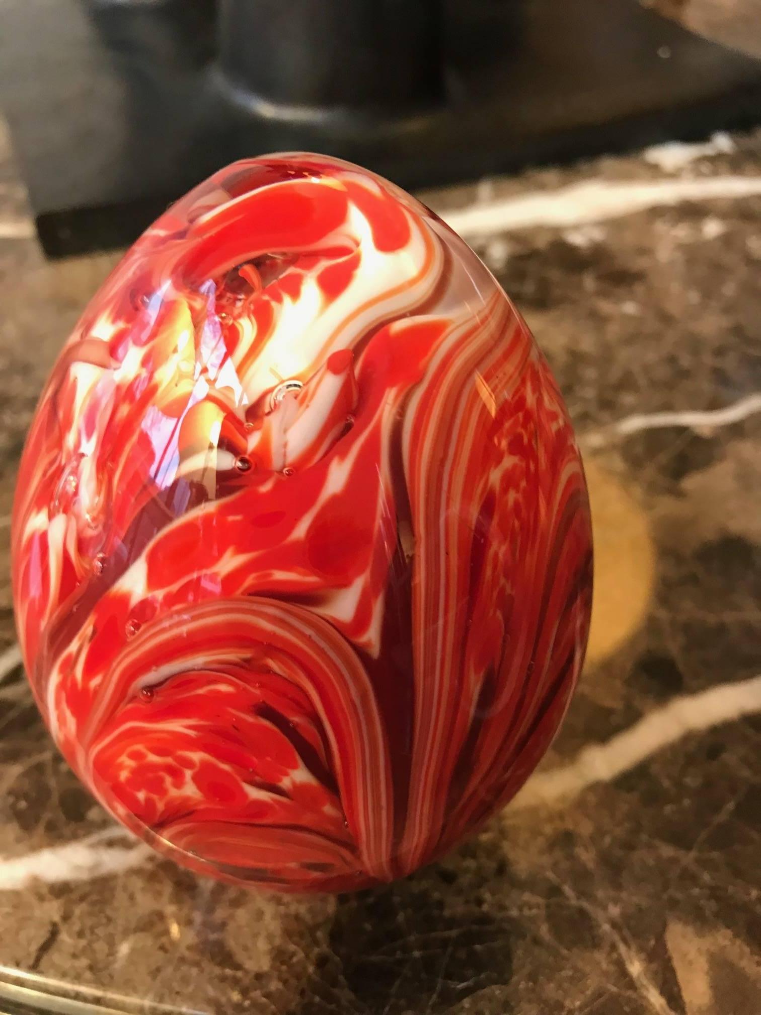 A large egg shaped Murano art glass paperweight with colorful swirl inclusions.
Beautiful decorative tabletop object.