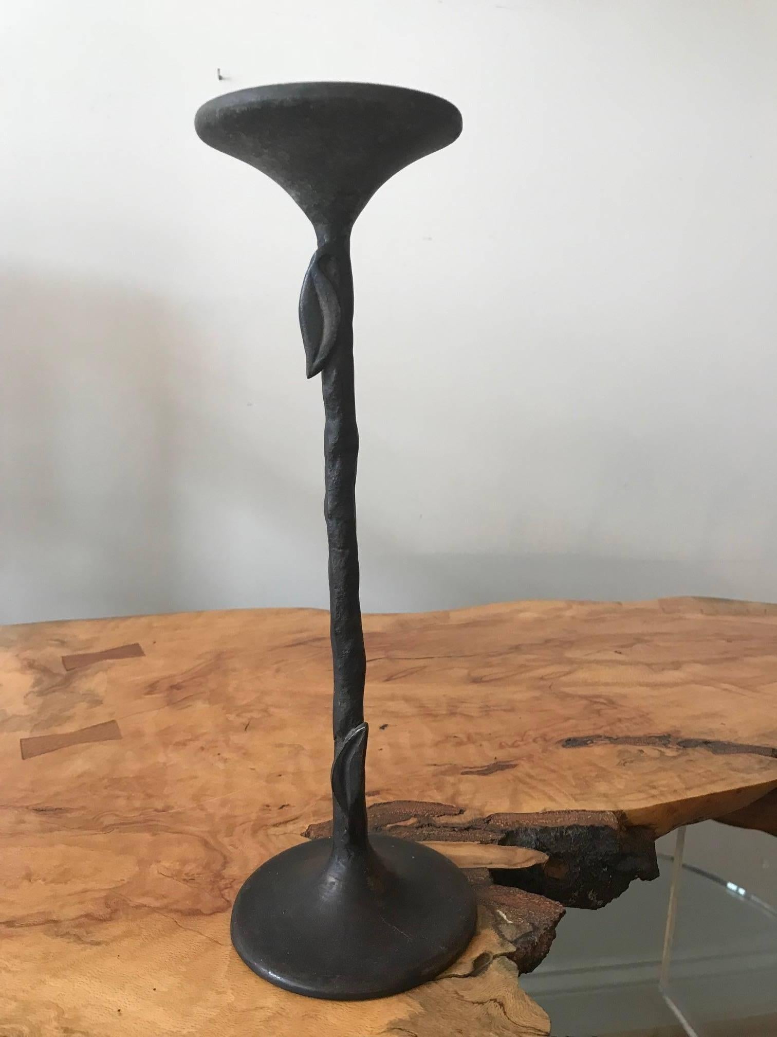 A Giacometti style hand-wrought bronze candleholder. The decorative object has applied leaves.