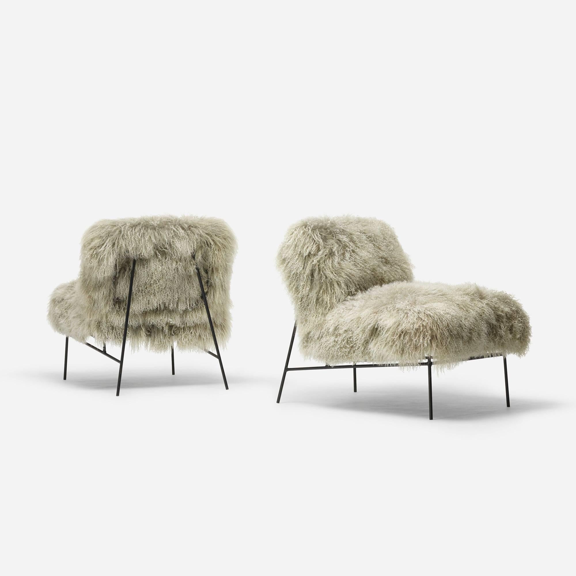 The simple, thin steel frame of these American lounge chairs allows the two-tone, grey to silver shearling to take center stage.
