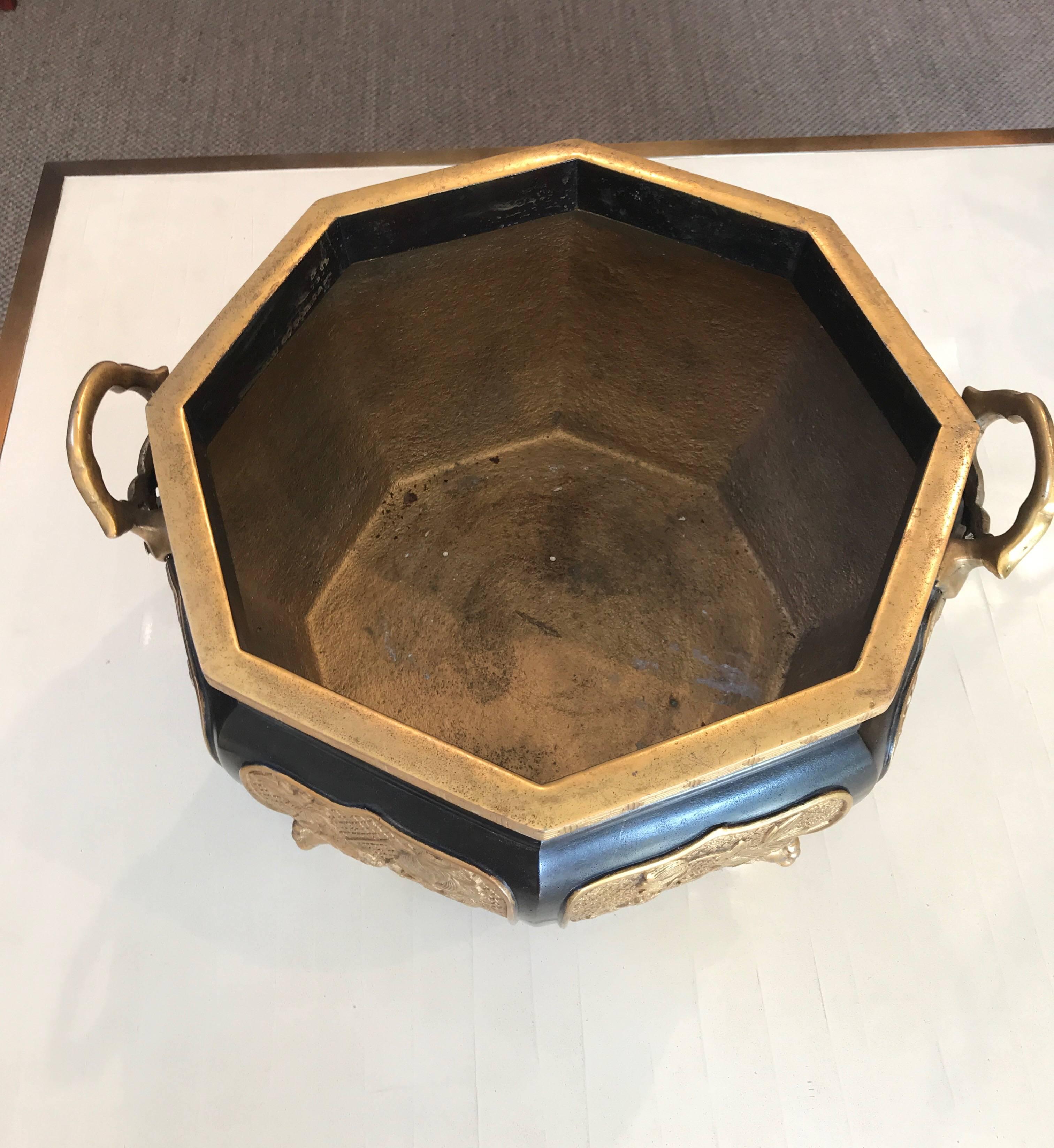A large eight sided bronze and gilt jardinière, with two handles.

There are eight panels with fantastic mythical animals. The top gilt border has a Greek key pattern, and the piece sits on four gilt feet.

Japanese.


