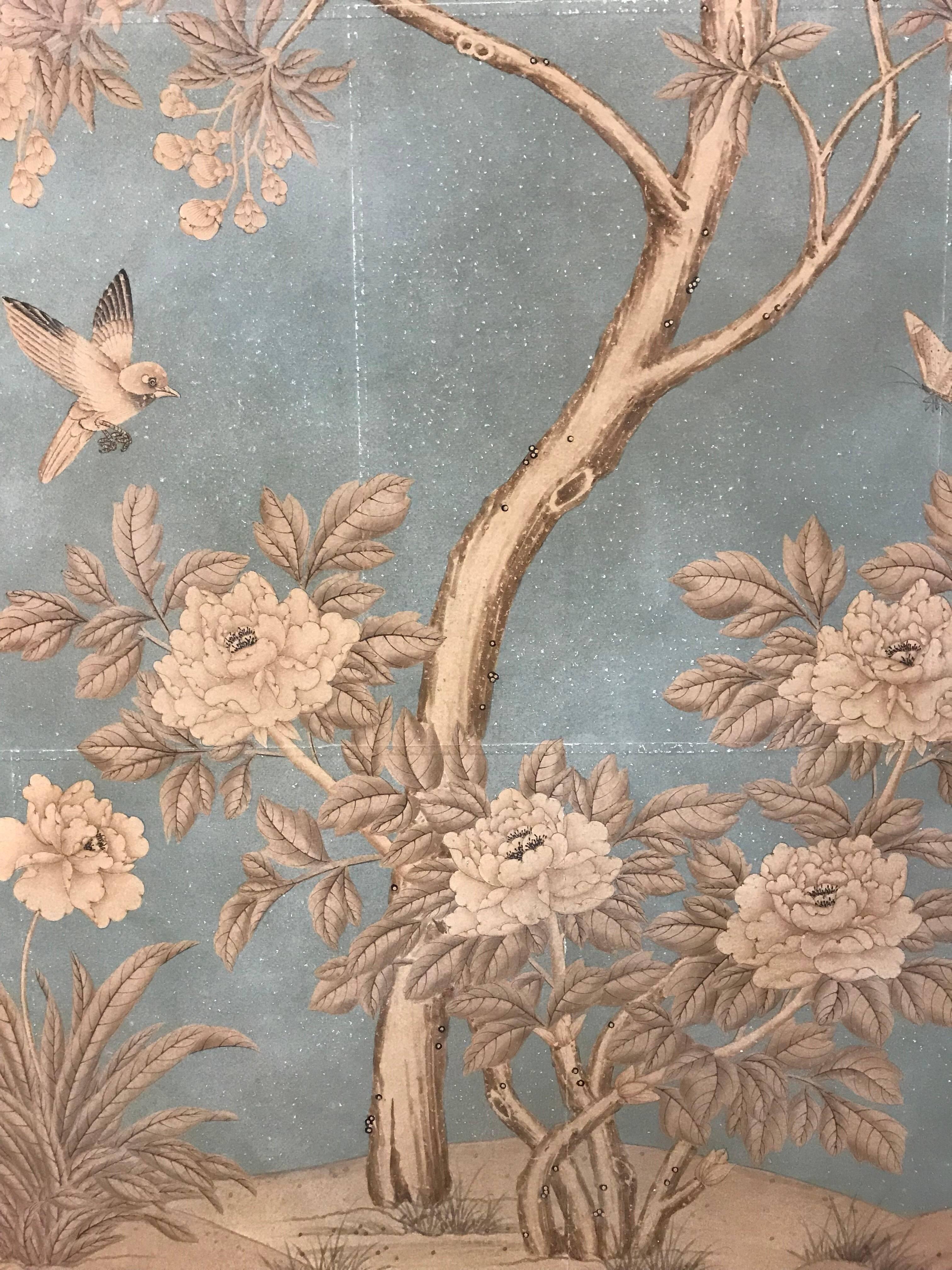 A pair of hand-painted Gracie wallpaper panels with Warren's Grove design mounted. A scene of flowering trees, birds and butterflies on pieced blue background, sanded and glazed to create patina.